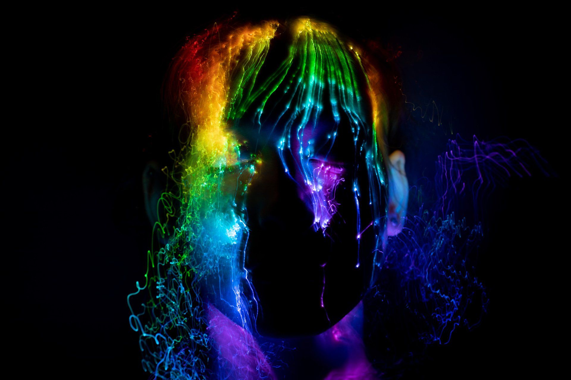 A woman 's head is surrounded by a rainbow of lights.