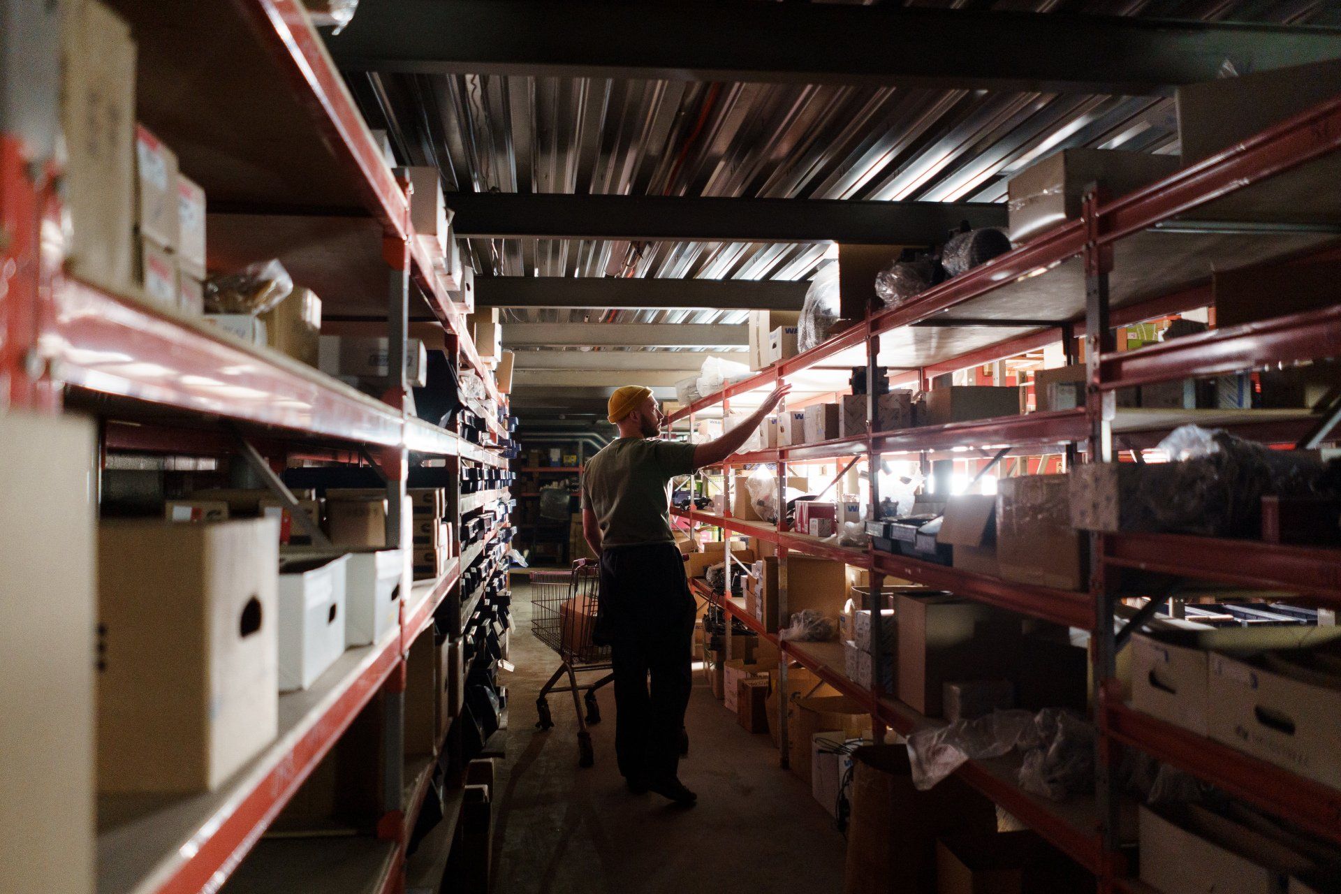 A man is standing in a warehouse looking at shelves