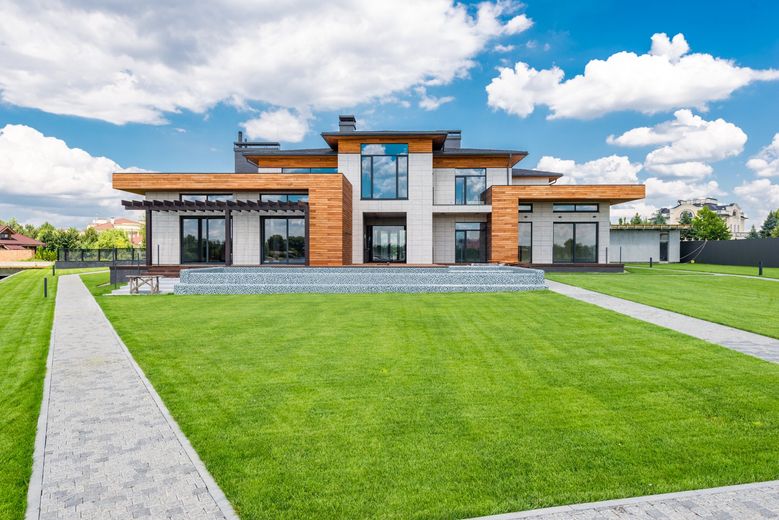 A large house with a lush green lawn in front of it.