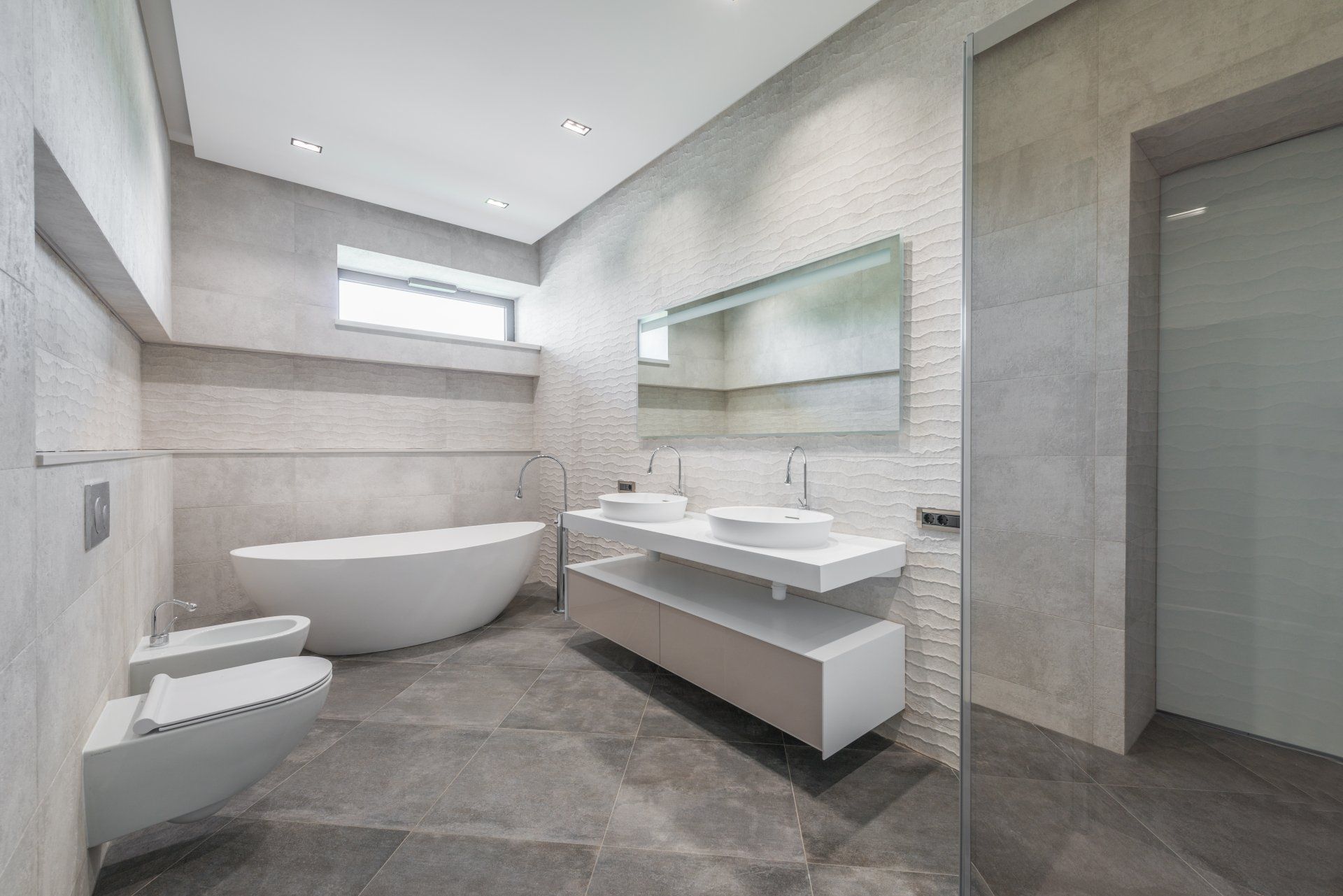 A bathroom with a bathtub , sinks , toilet and shower.