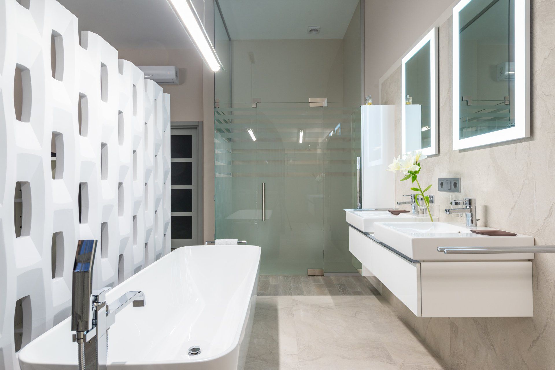 Compact bathroom with sink and enclosed glass shower area.