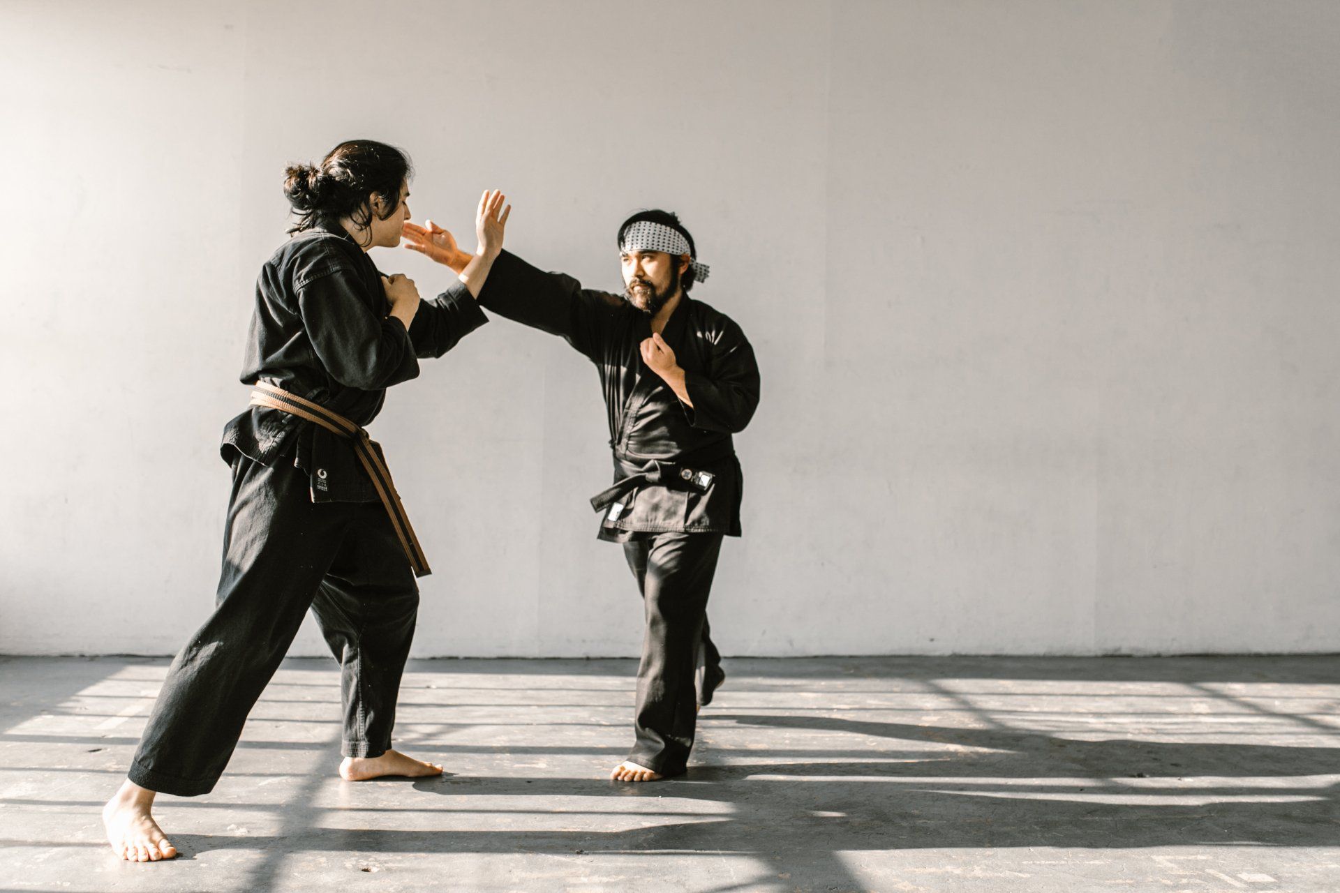 a man and a woman are practicing karate in a gym