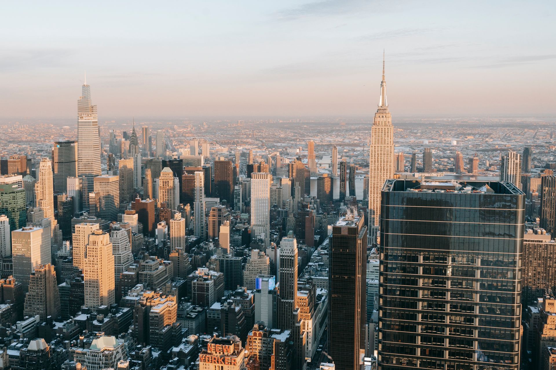 Skyline of New York City buildings, lit by sunlight.