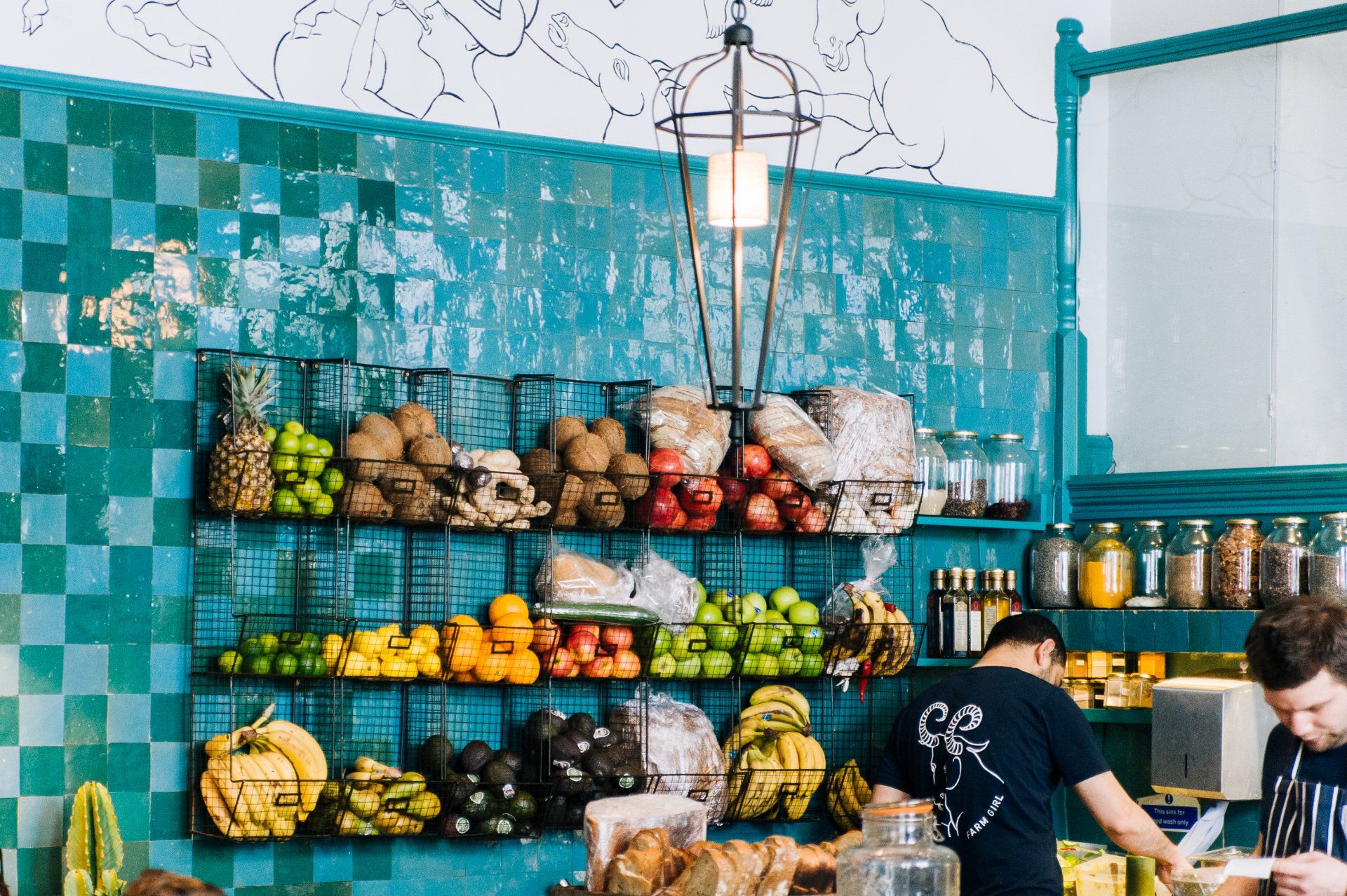 A man is standing in front of a display of fruits and vegetables.