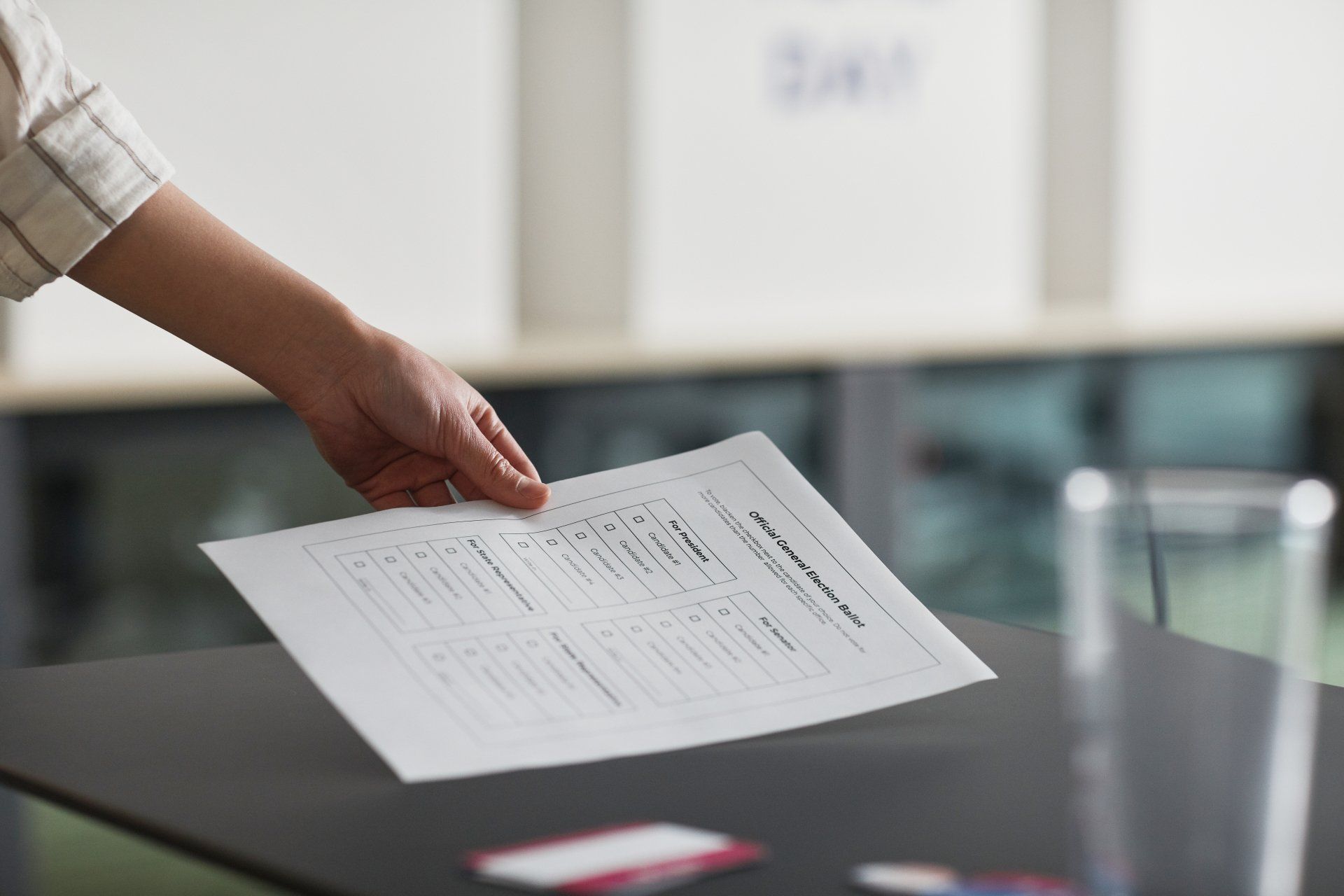 A hand holding a printed document over a conference table in an office setting