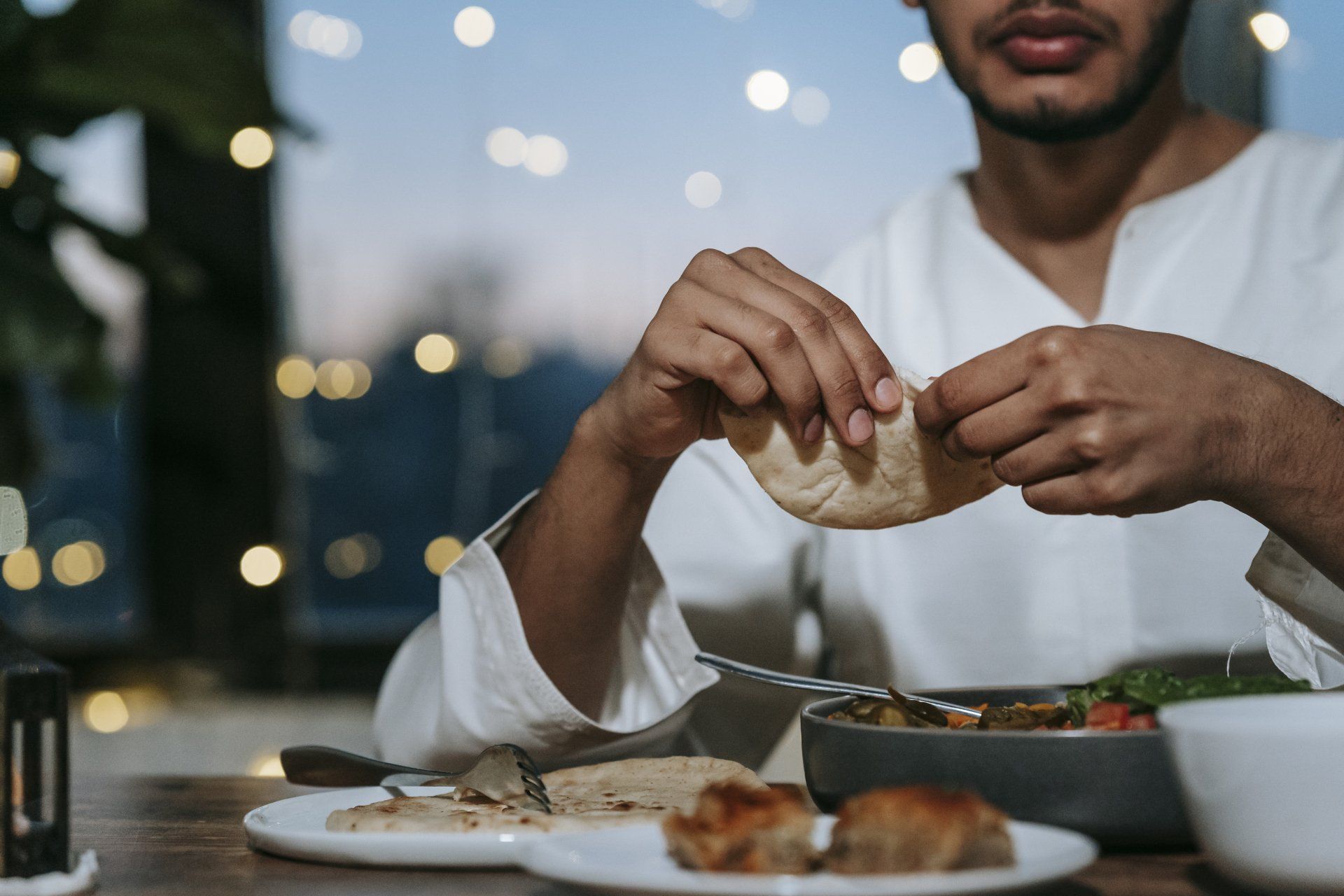 A man is sitting at a table eating food.