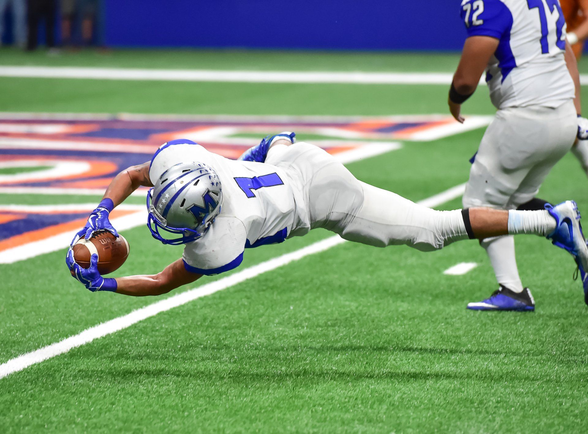 A football player is diving for the ball on the field and Stay competitive in a rapidly evolving market with our specialized training programs. Learn from experts and gain the skills that matter today