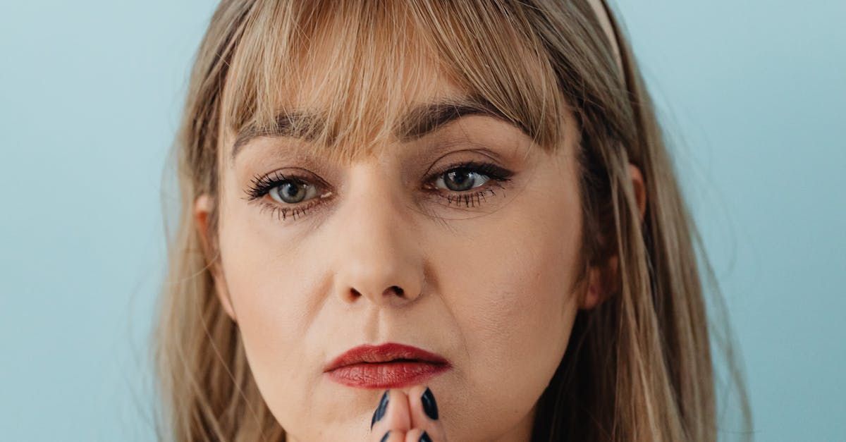 Um close do rosto de uma mulher com a mão no queixo.