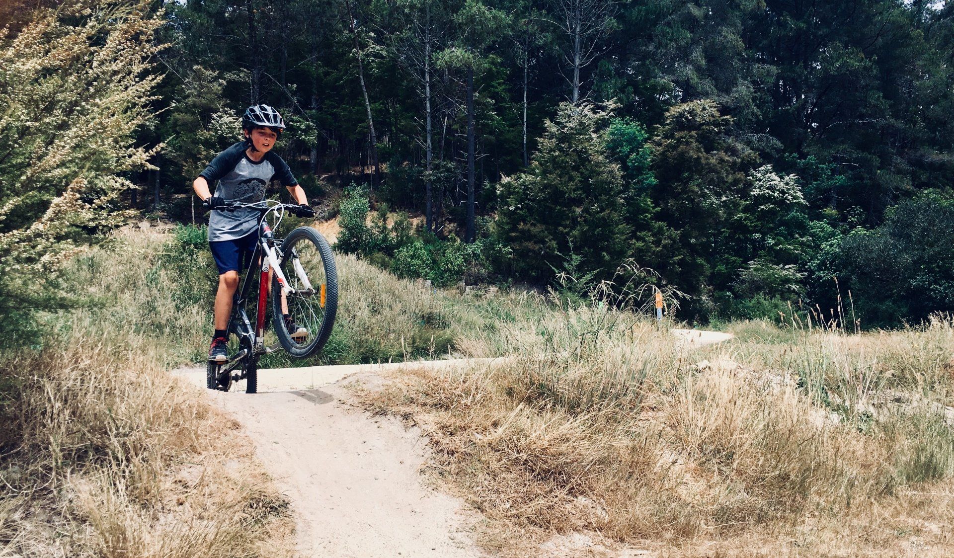 A person is riding a bike down a dirt path near Woods End Landing in Bamfield BC