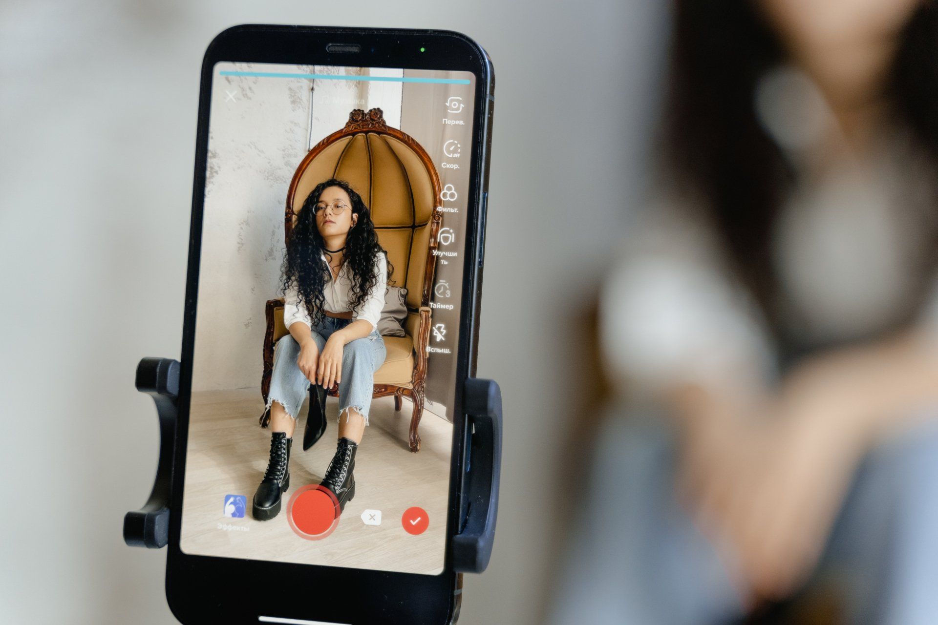 A woman is sitting in a chair on a cell phone.