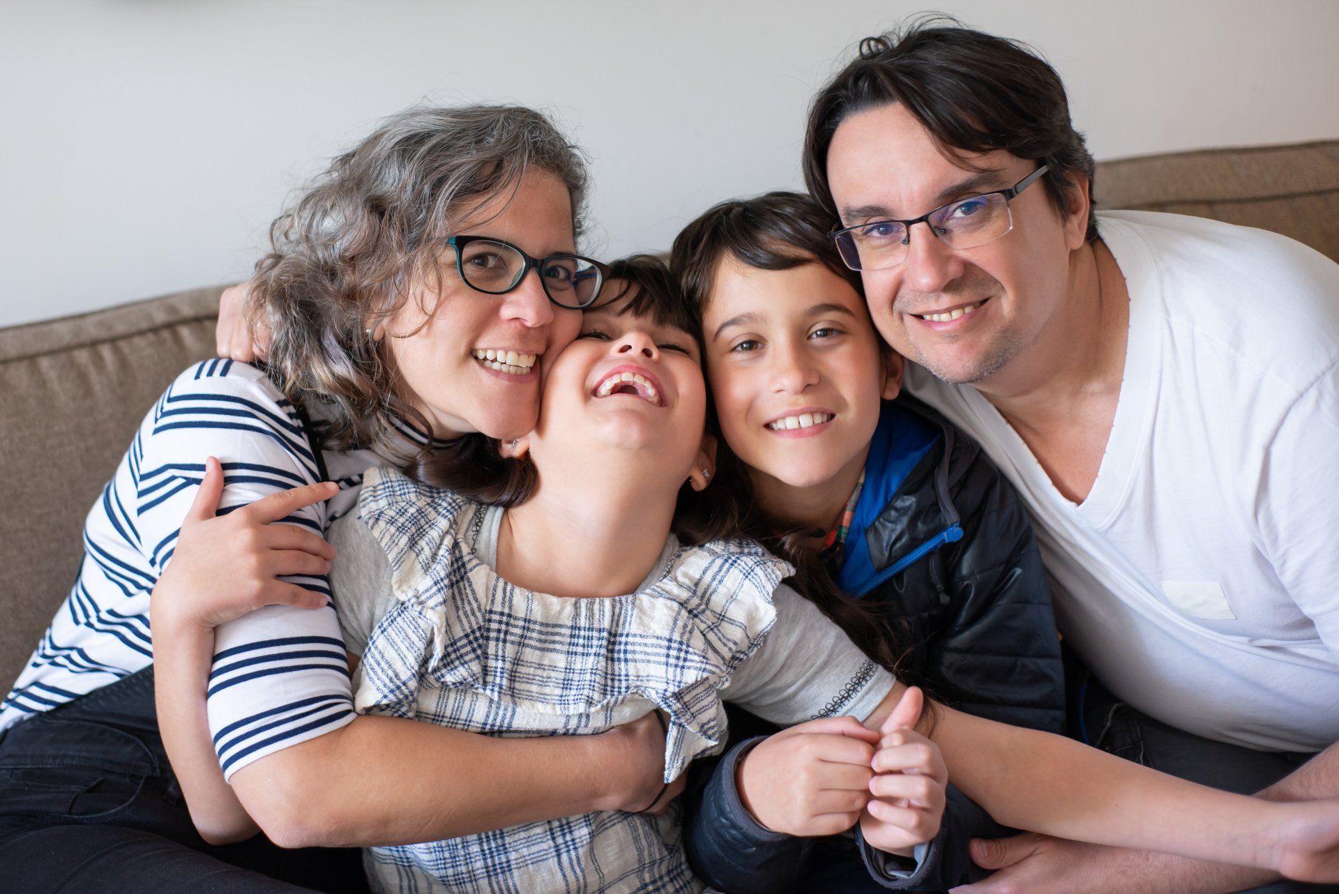 A family is posing for a picture while sitting on a couch.