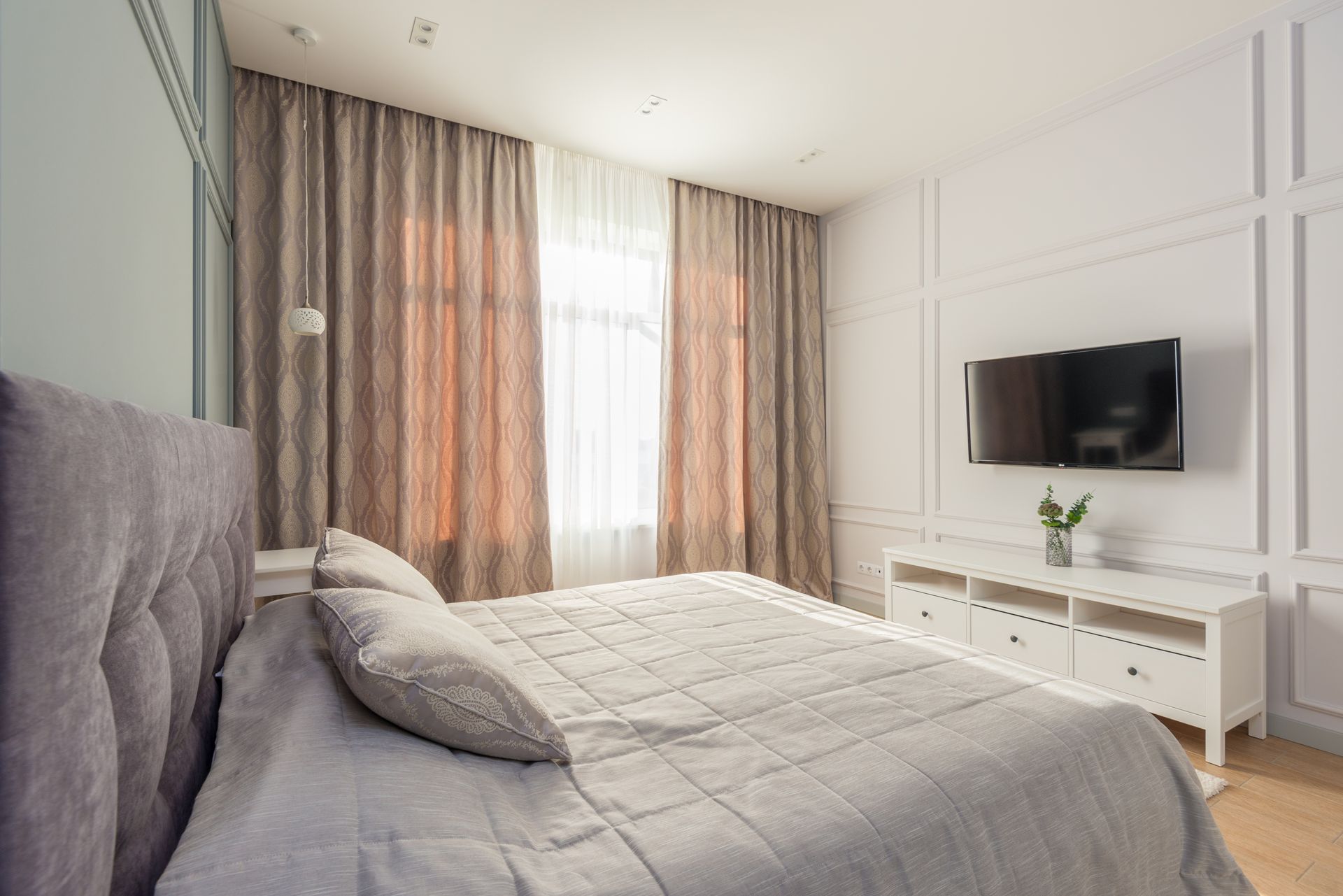A bedroom with a bed , television and window.