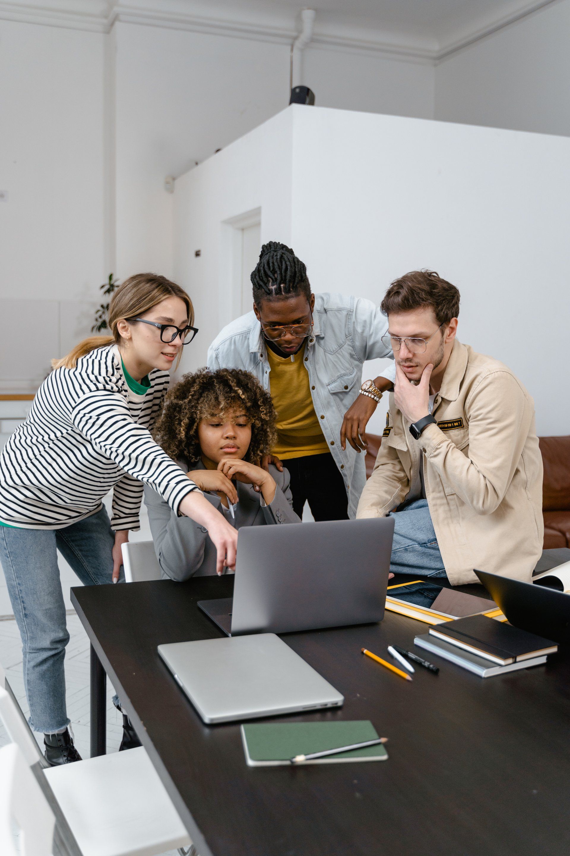A group of people are looking at a laptop computer.
