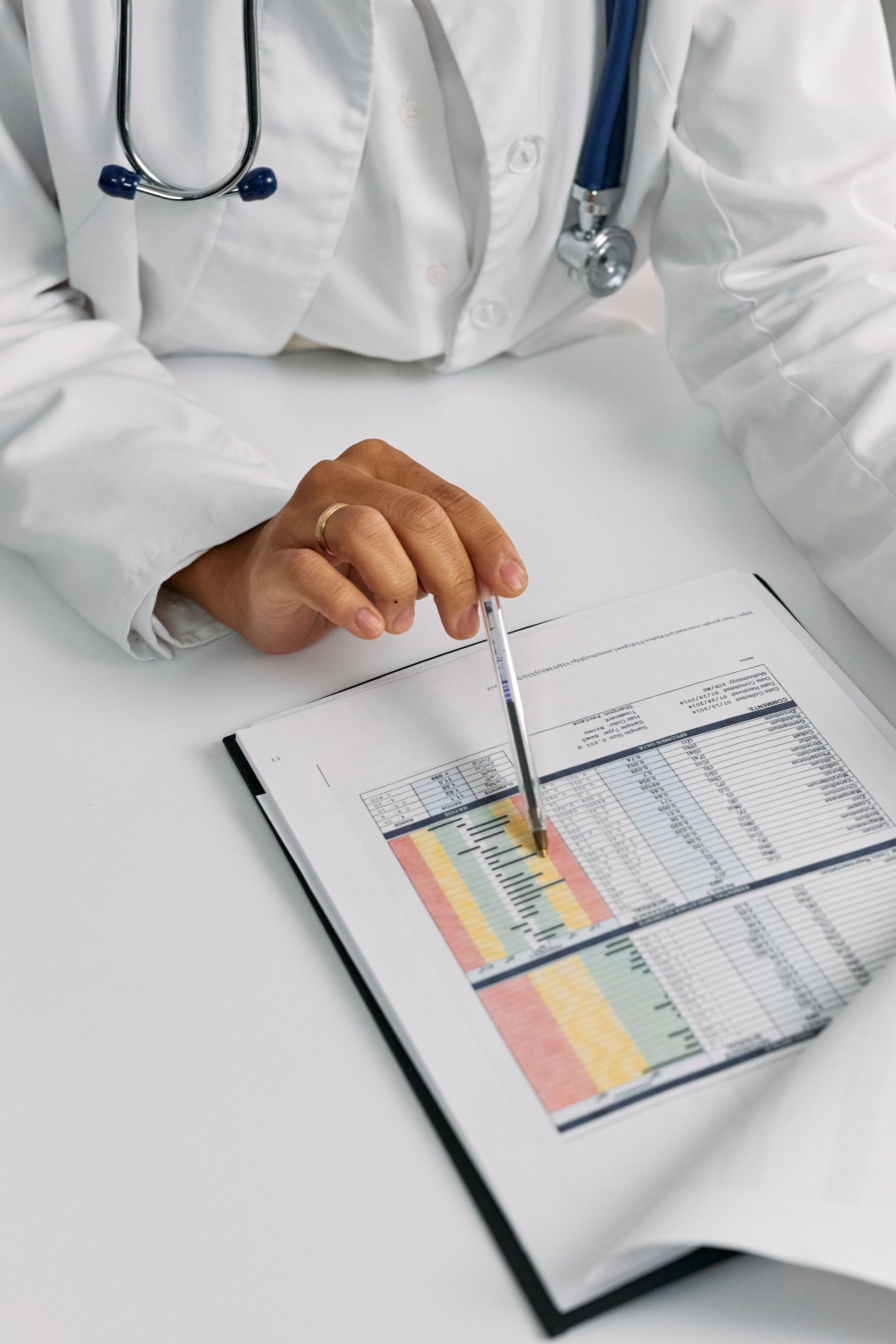 A doctor is using a pen to point at a chart
