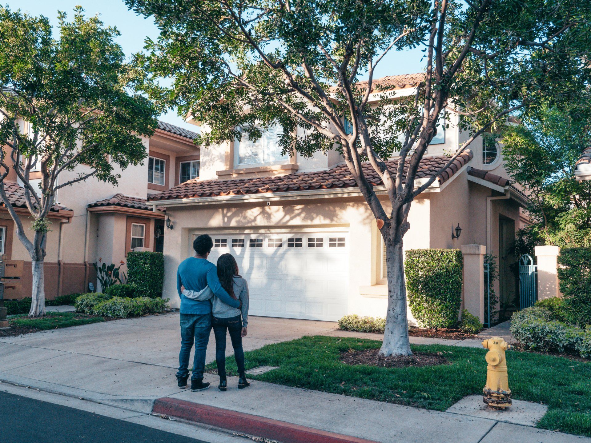 A man and woman are standing in front of a house