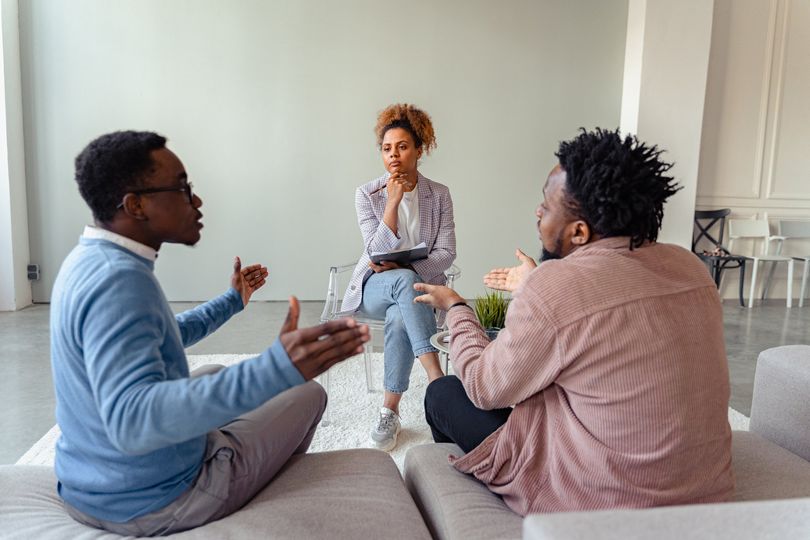 Female Psychologist talking with happy man in the office