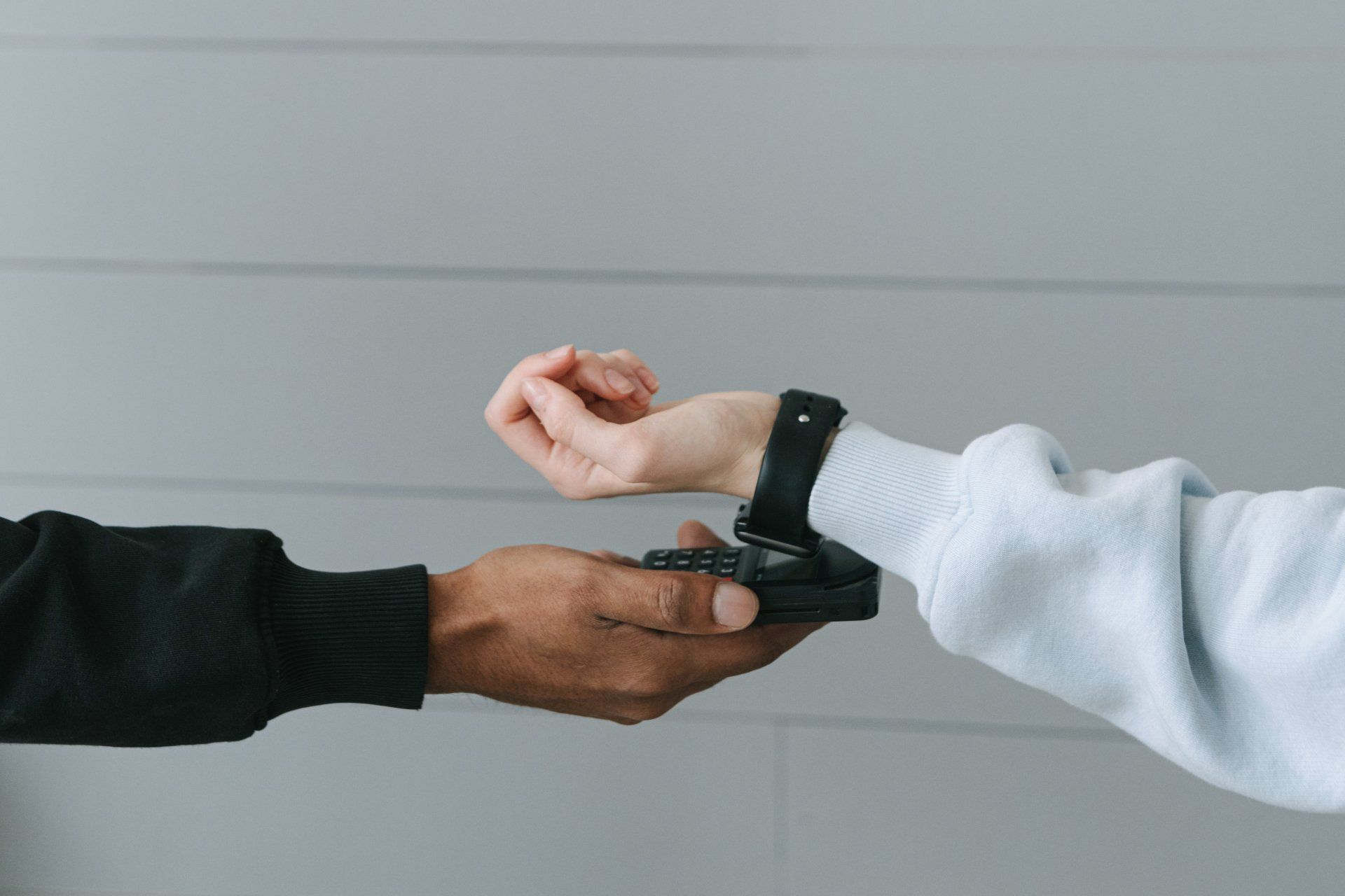A man is holding a smart watch on a woman 's wrist.