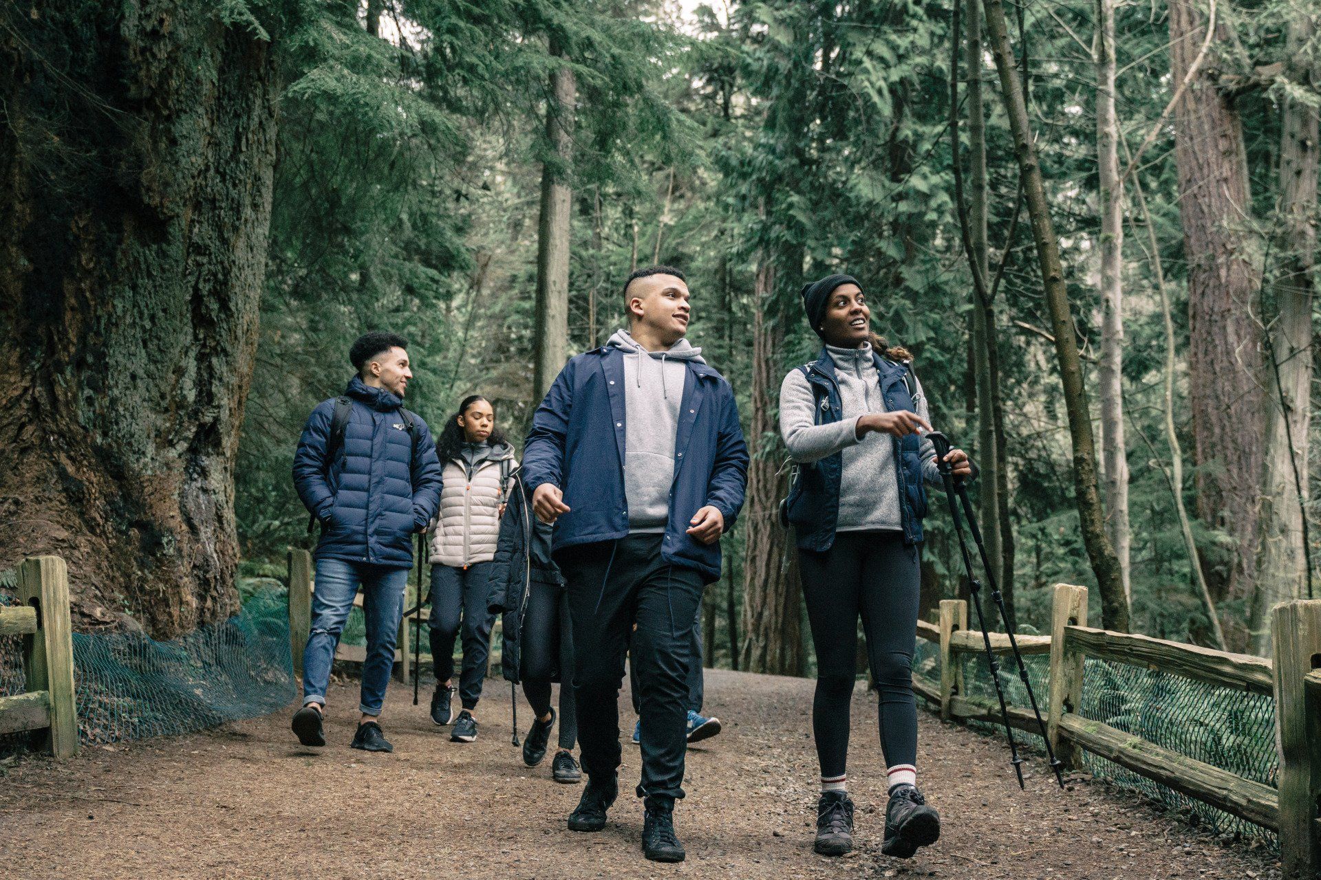 A group of people are walking down a path in the woods.
