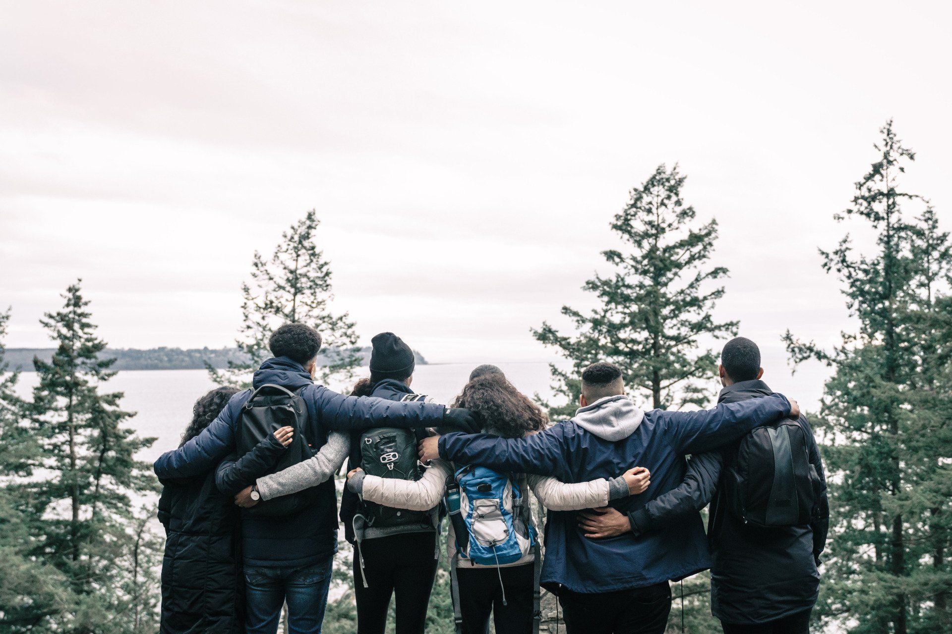 A group of people are putting their hands together in a huddle.