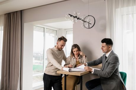 A man and a woman are sitting at a table with a man in a suit.