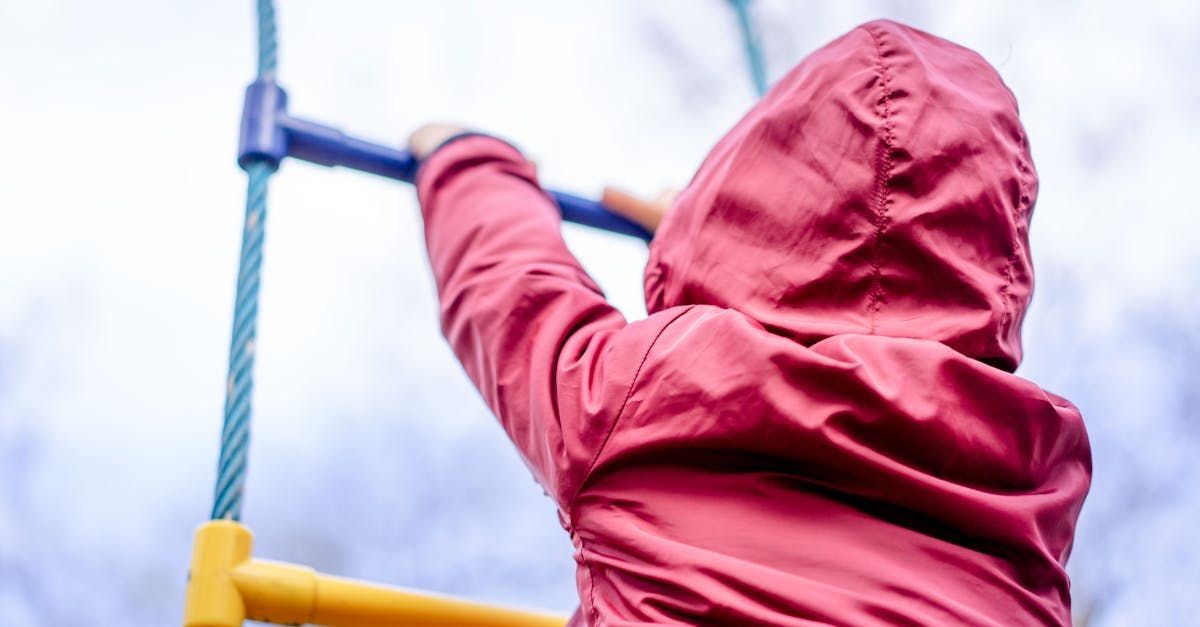 A child is climbing a rope ladder at a playground.