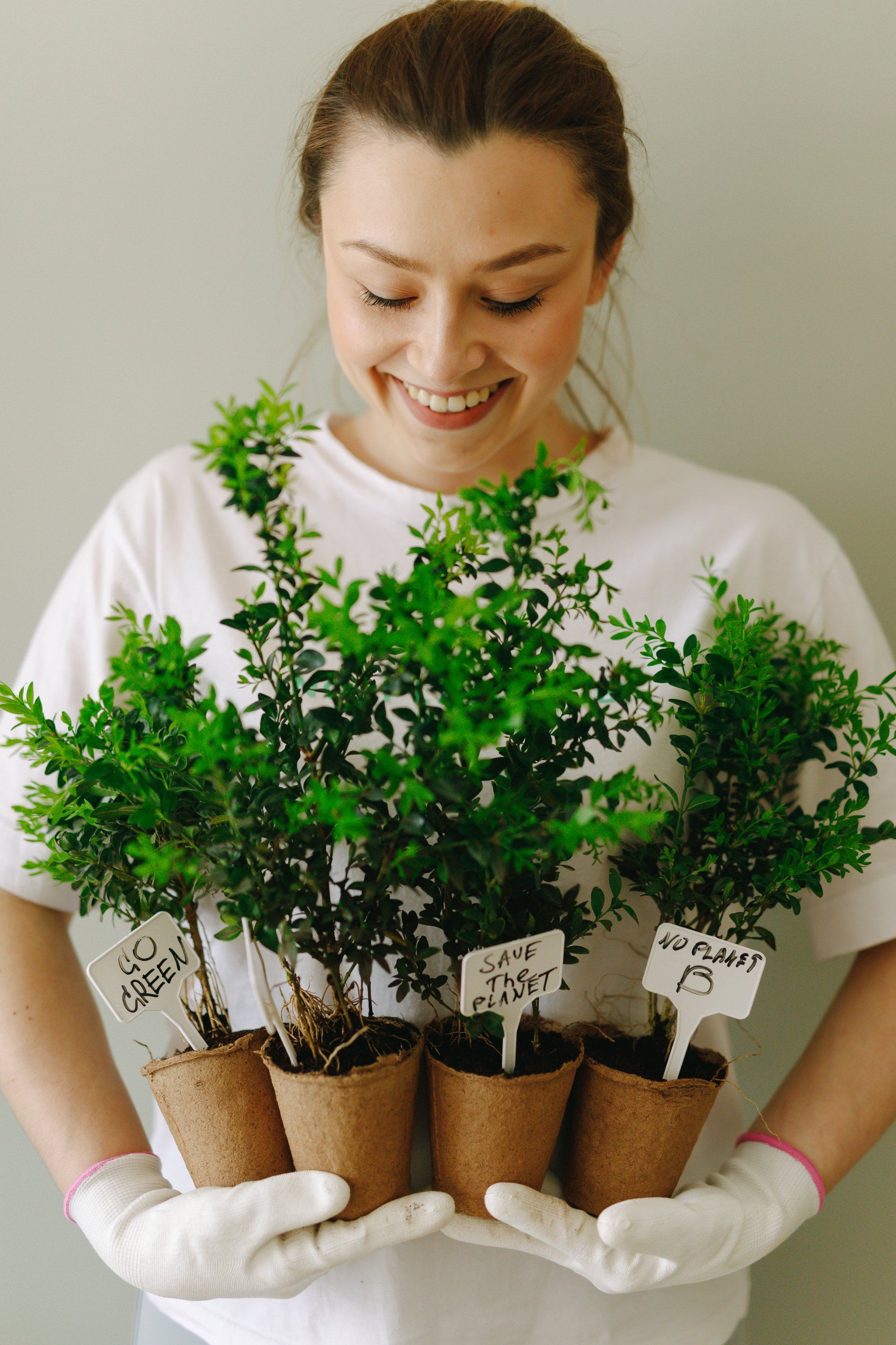 Woman smiling and holding potted plants
