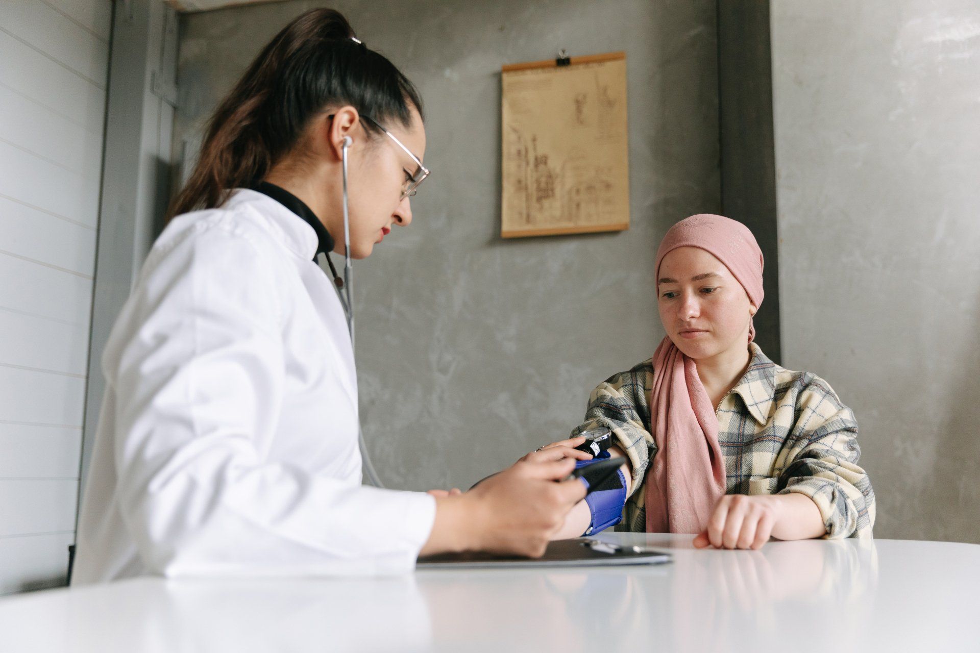 a doctor is talking to a patient with cancer who is sitting at a table .