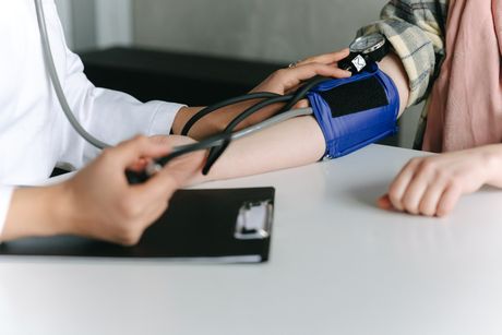 Blood pressure being measured on a patient's arm in the office