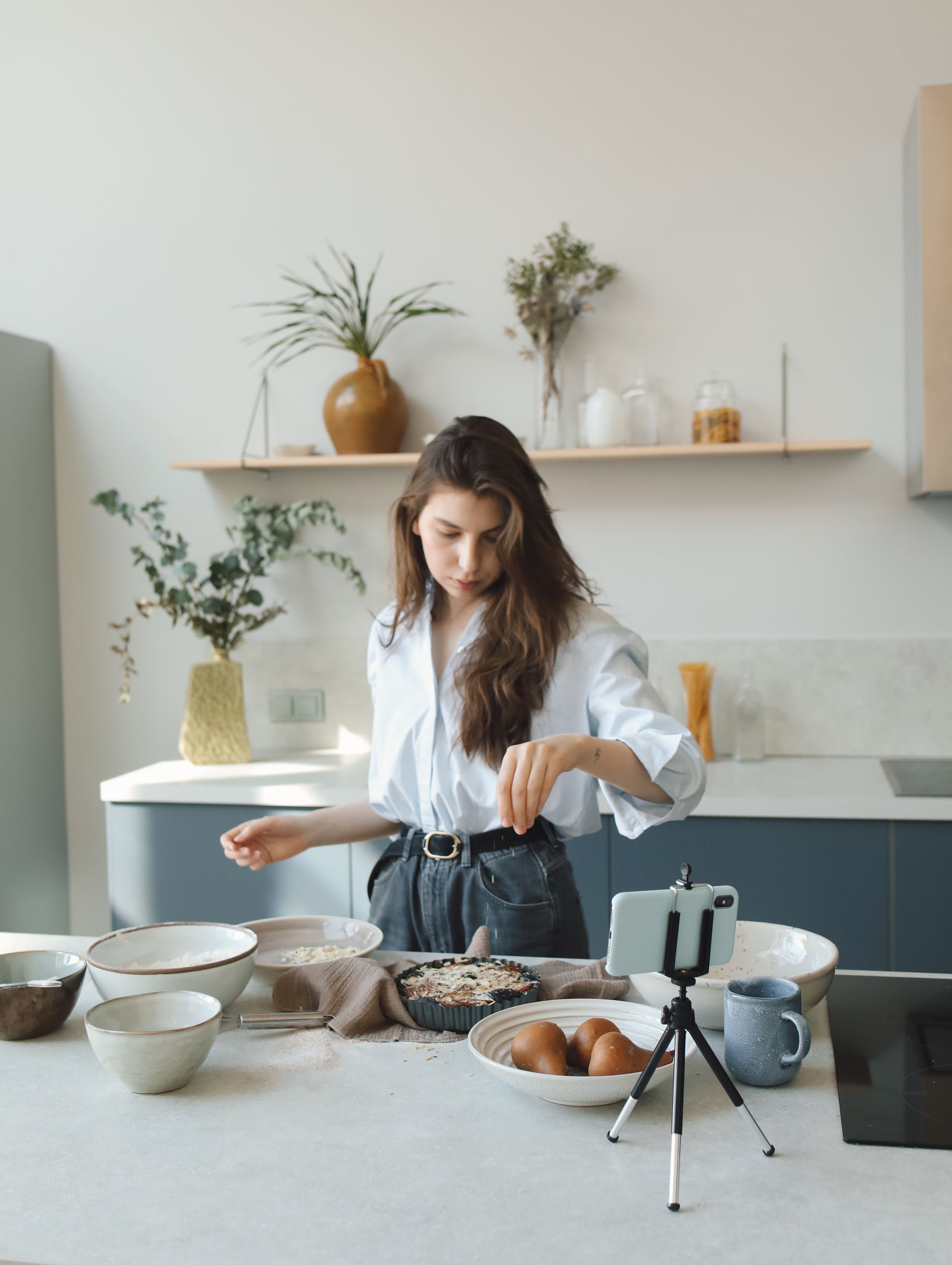 A woman is standing in a kitchen preparing food.