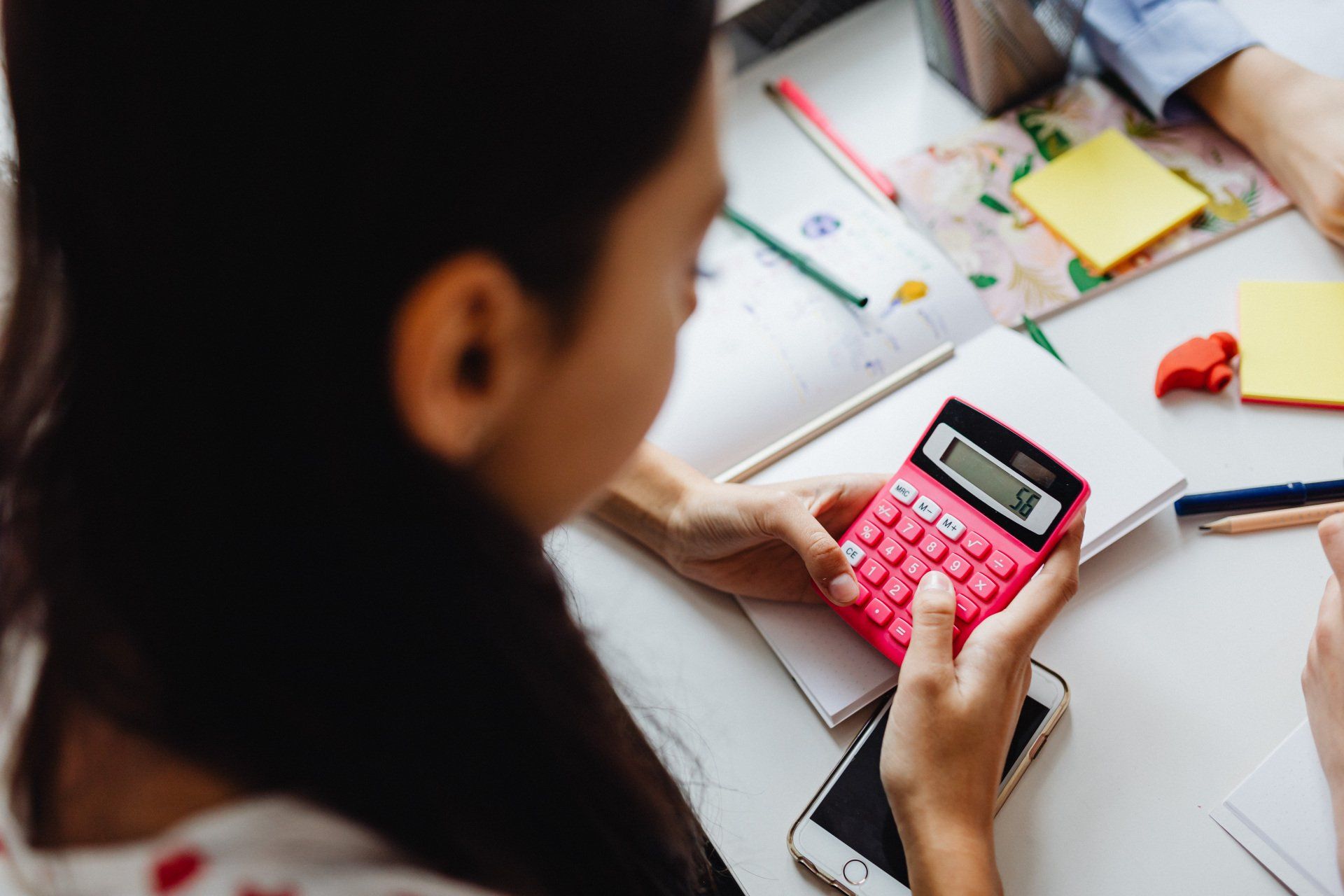Young girl using a calculator to her math homework