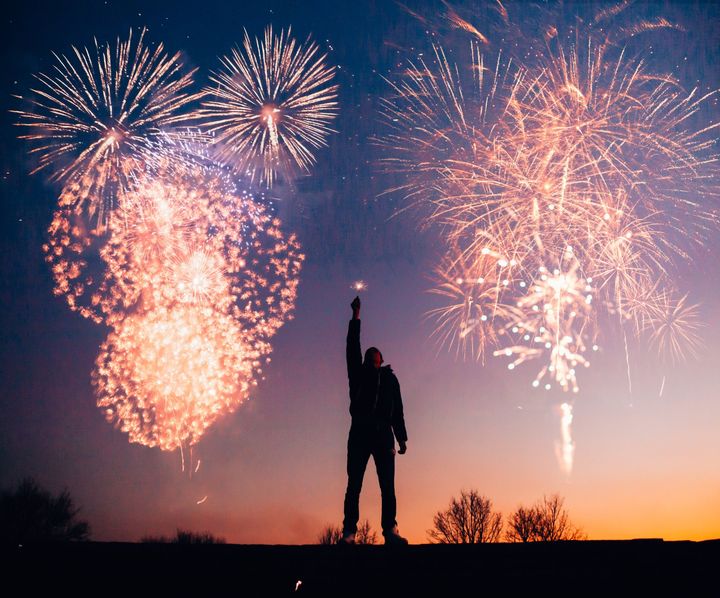 A man is standing in front of a fireworks display
