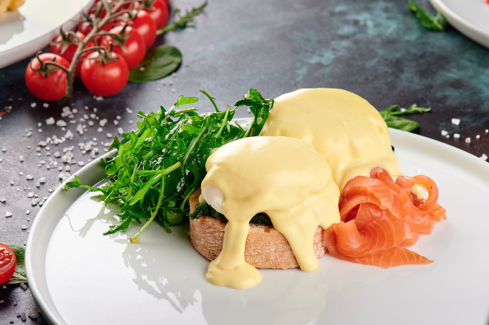 A plate of food with eggs benedict and smoked salmon on a table.