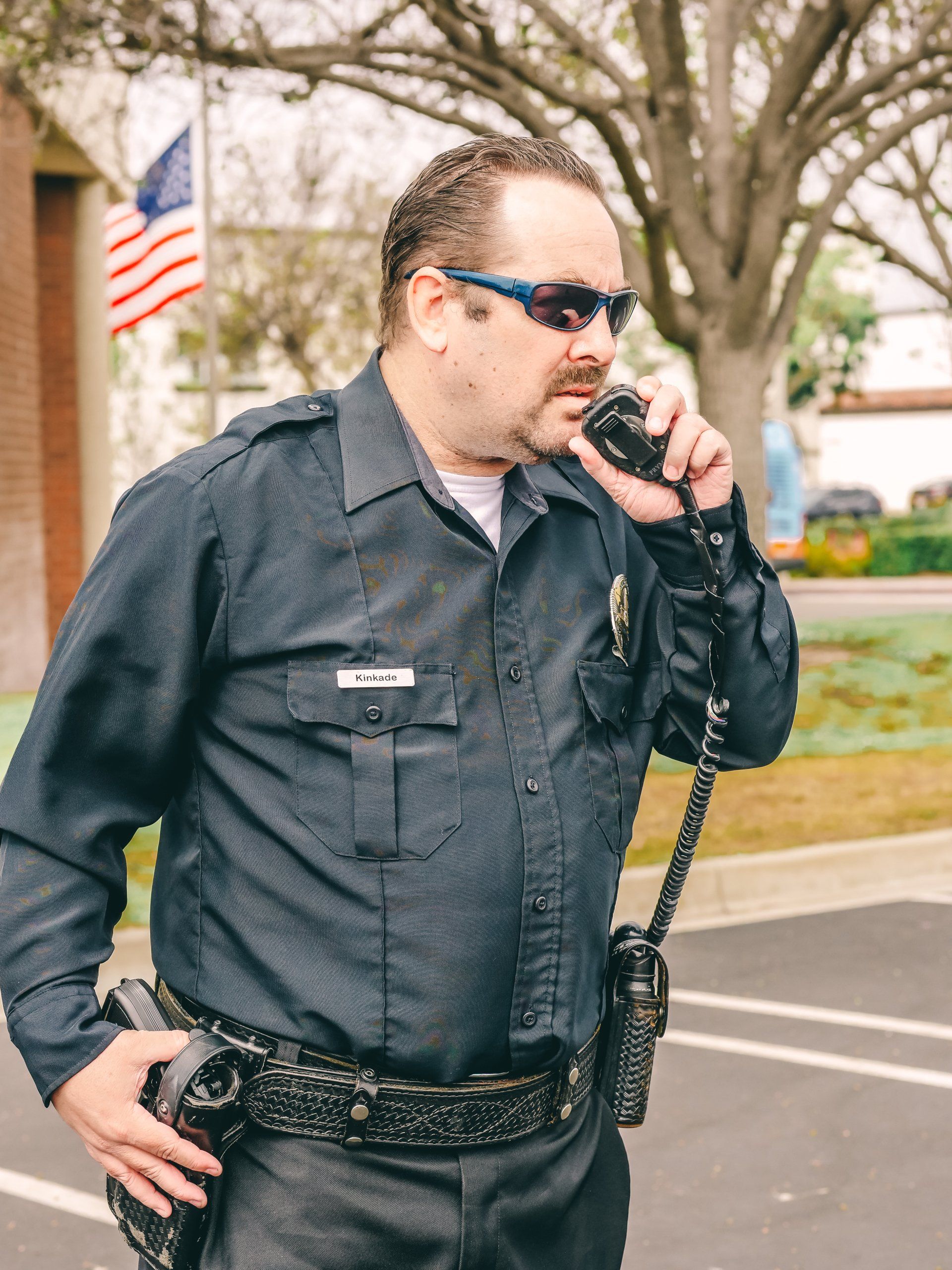 A police officer is talking on a walkie talkie
