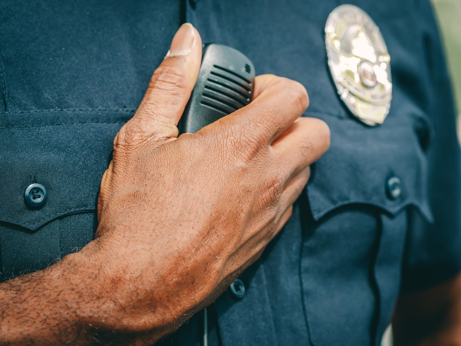 A police officer is holding a microphone in his hand.