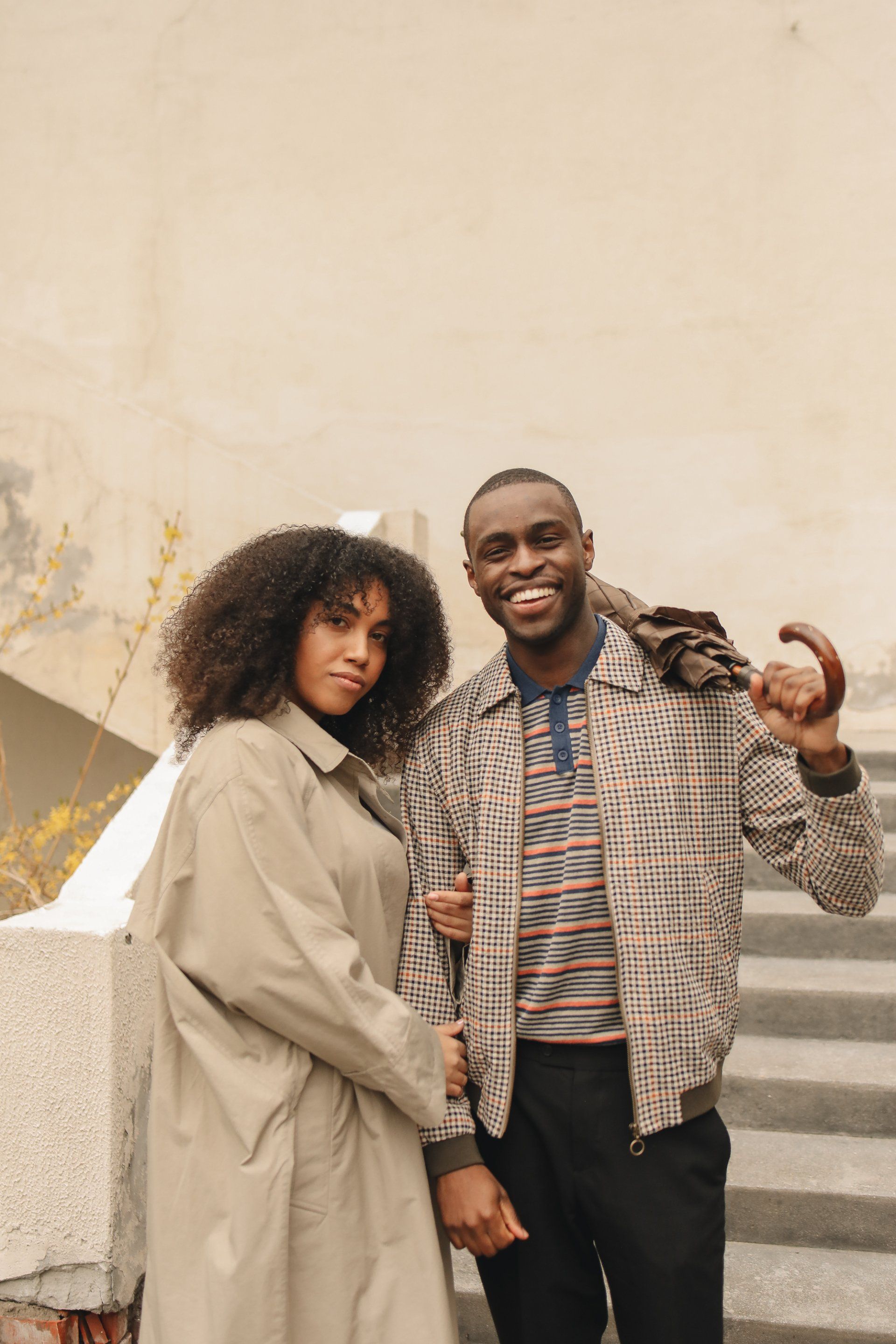 A man and a woman are standing next to each other on a set of stairs.
