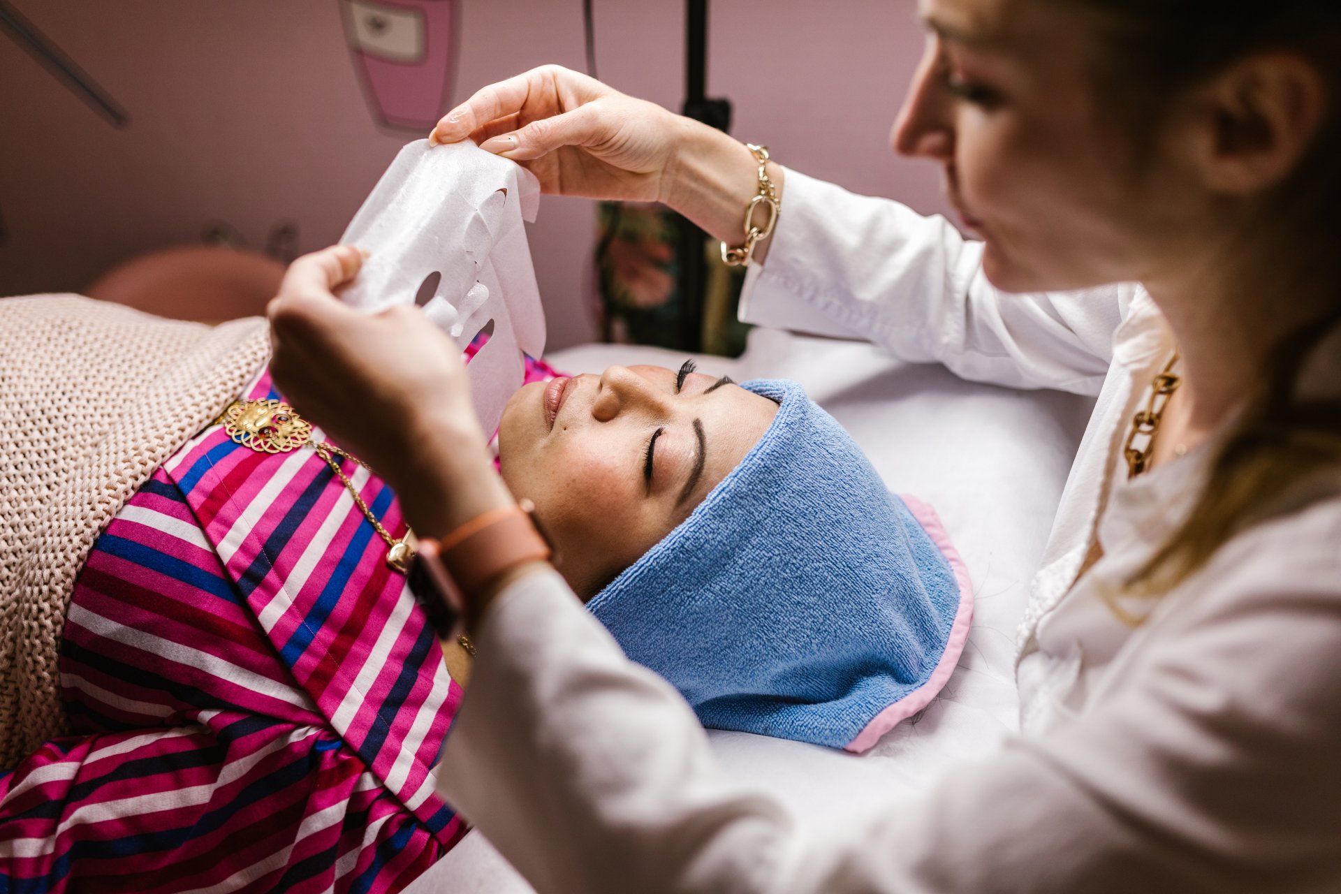 A woman is getting a facial treatment at a beauty salon.