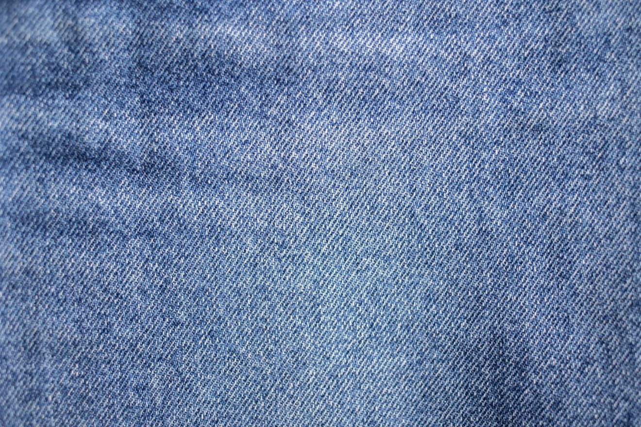 A close up of a blue denim fabric texture.