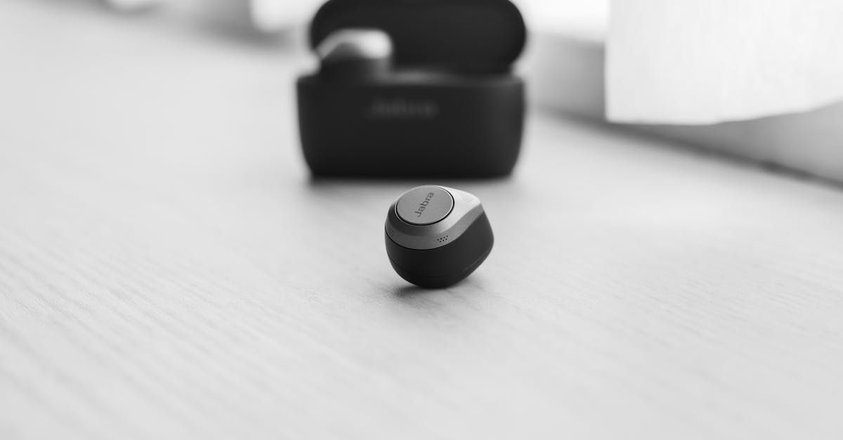 A pair of ear buds sitting on top of a wooden table.