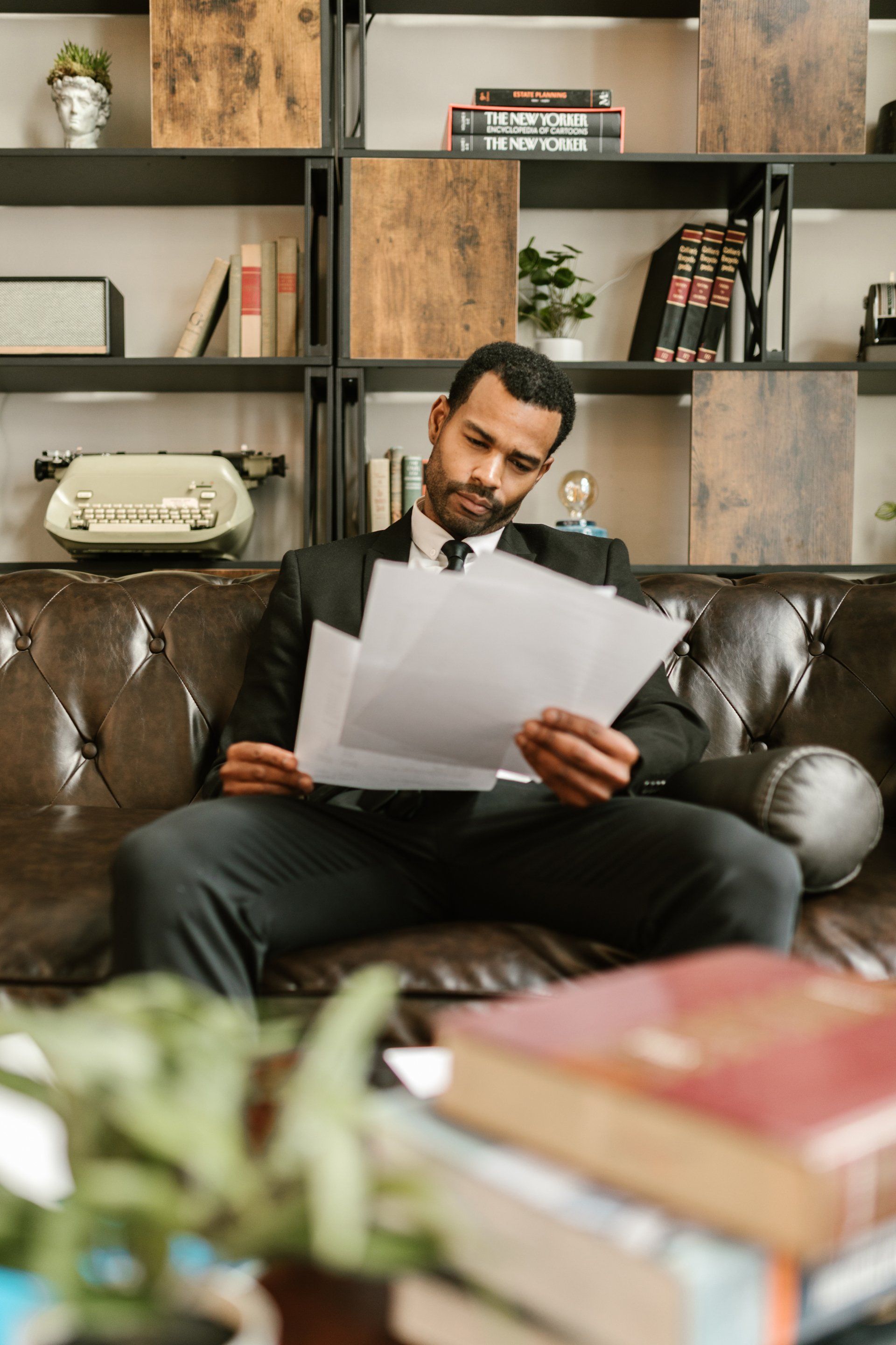 Man sat on sofa looking at papers - Employee wellbeing and benefits