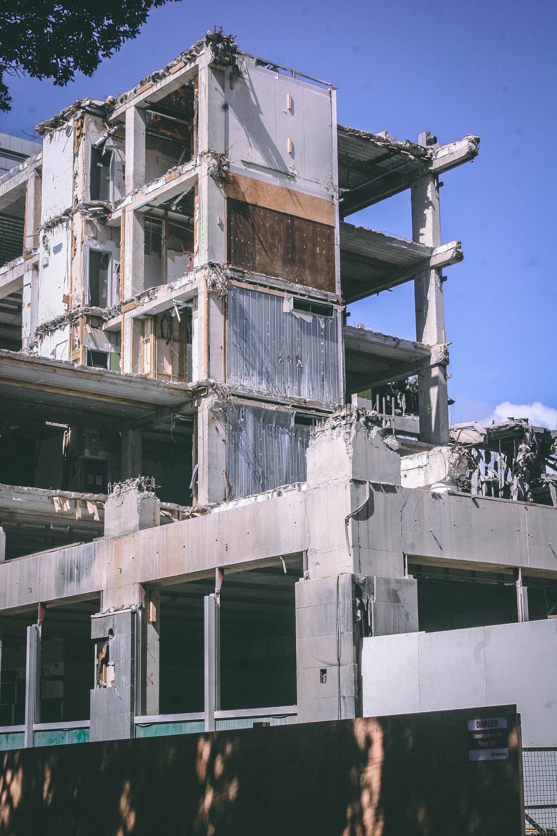 Partially demolished concrete building with exposed interior framing.