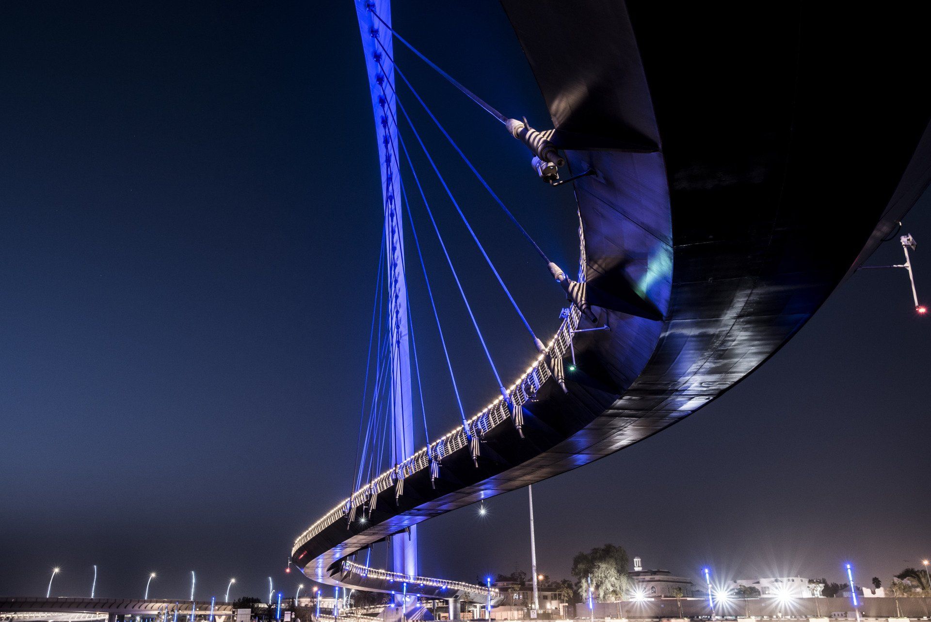 Uma ponte com luzes azuis iluminada à noite.