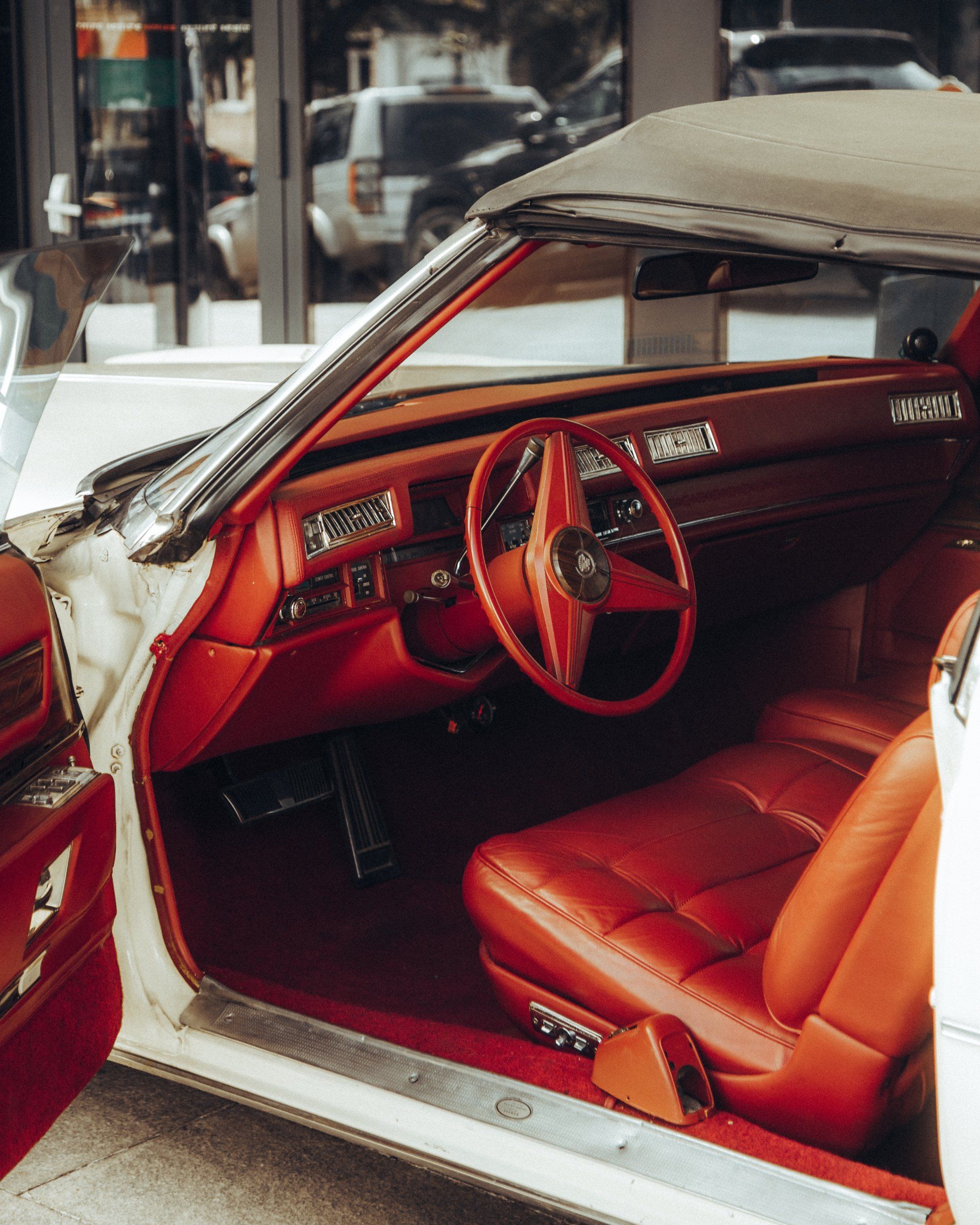 A white car with red seats and a steering wheel