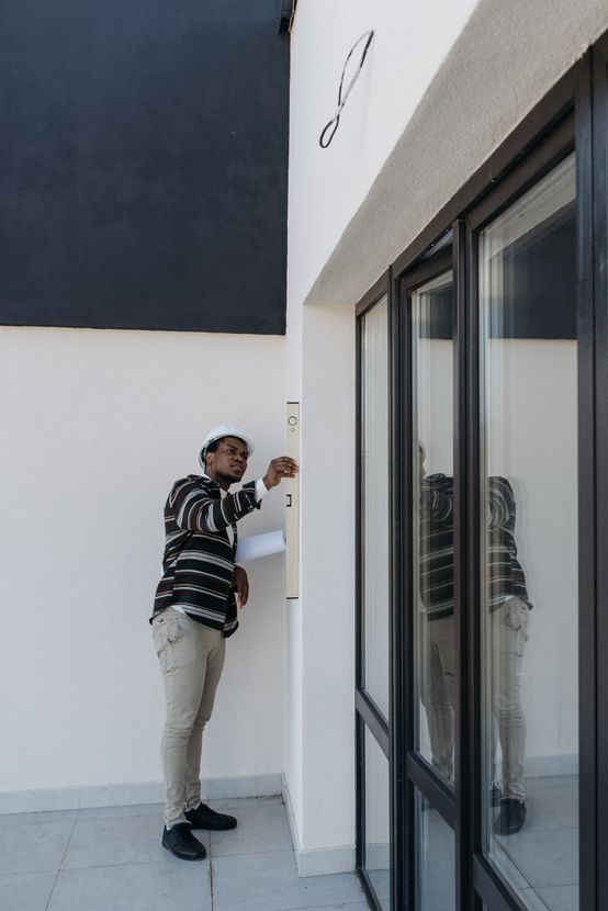 A man is measuring a wall with a level.