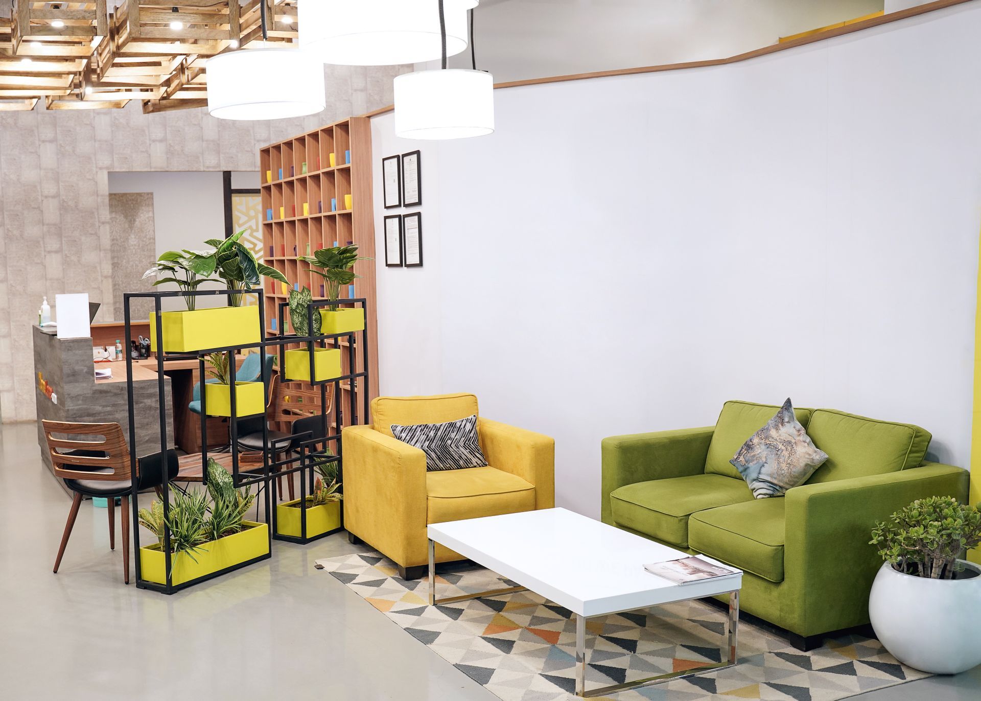 Un salon avec un canapé vert, une chaise jaune et une table basse blanche.