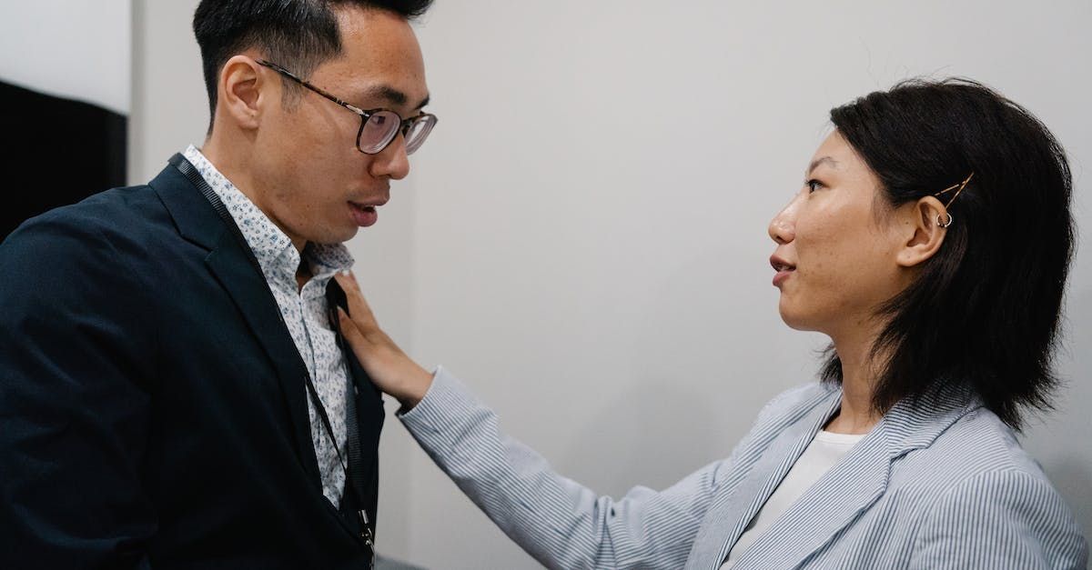 A woman is putting her hand on a man 's shoulder.