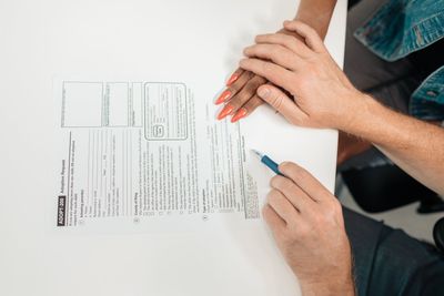 A man and a woman are sitting at a table signing a document.