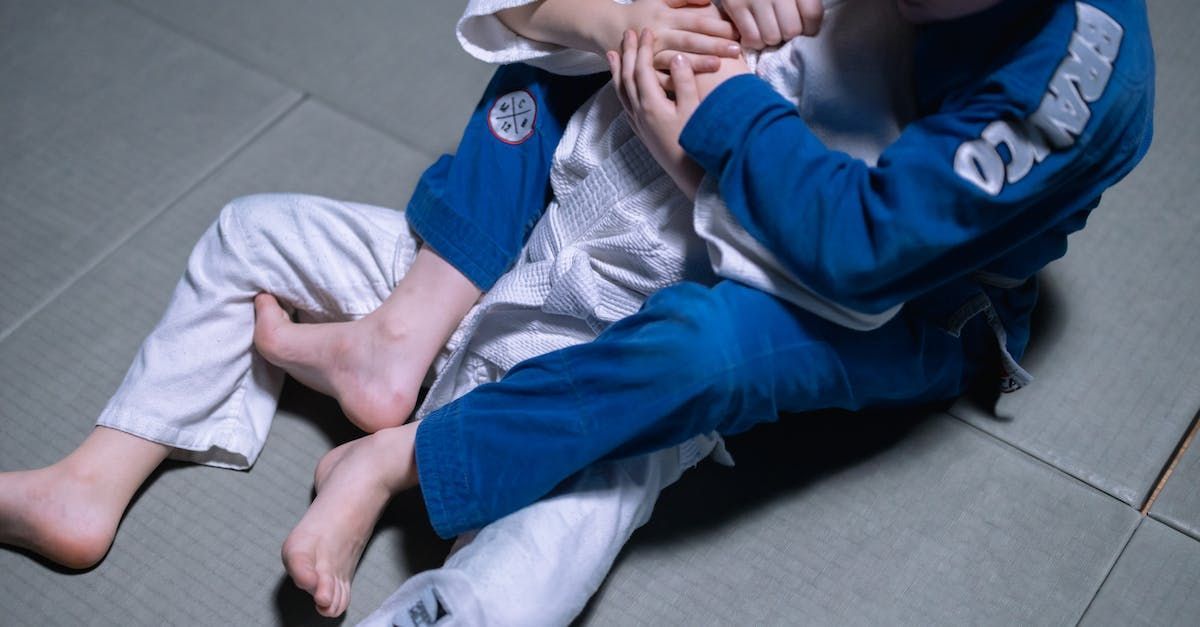 two young boys are practicing judo on a mat
