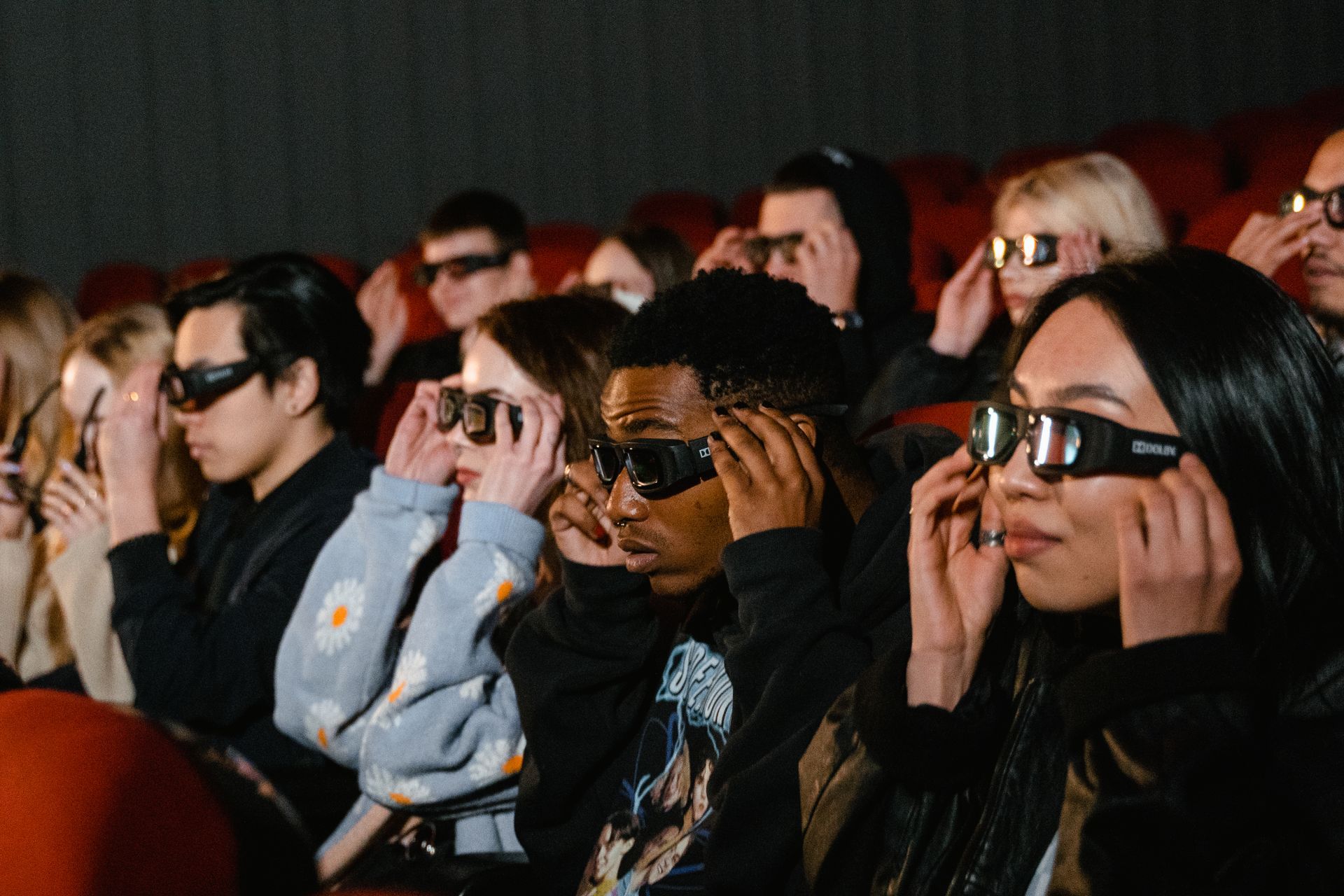 3D gözlük takan insanlar sinemada film izliyor.