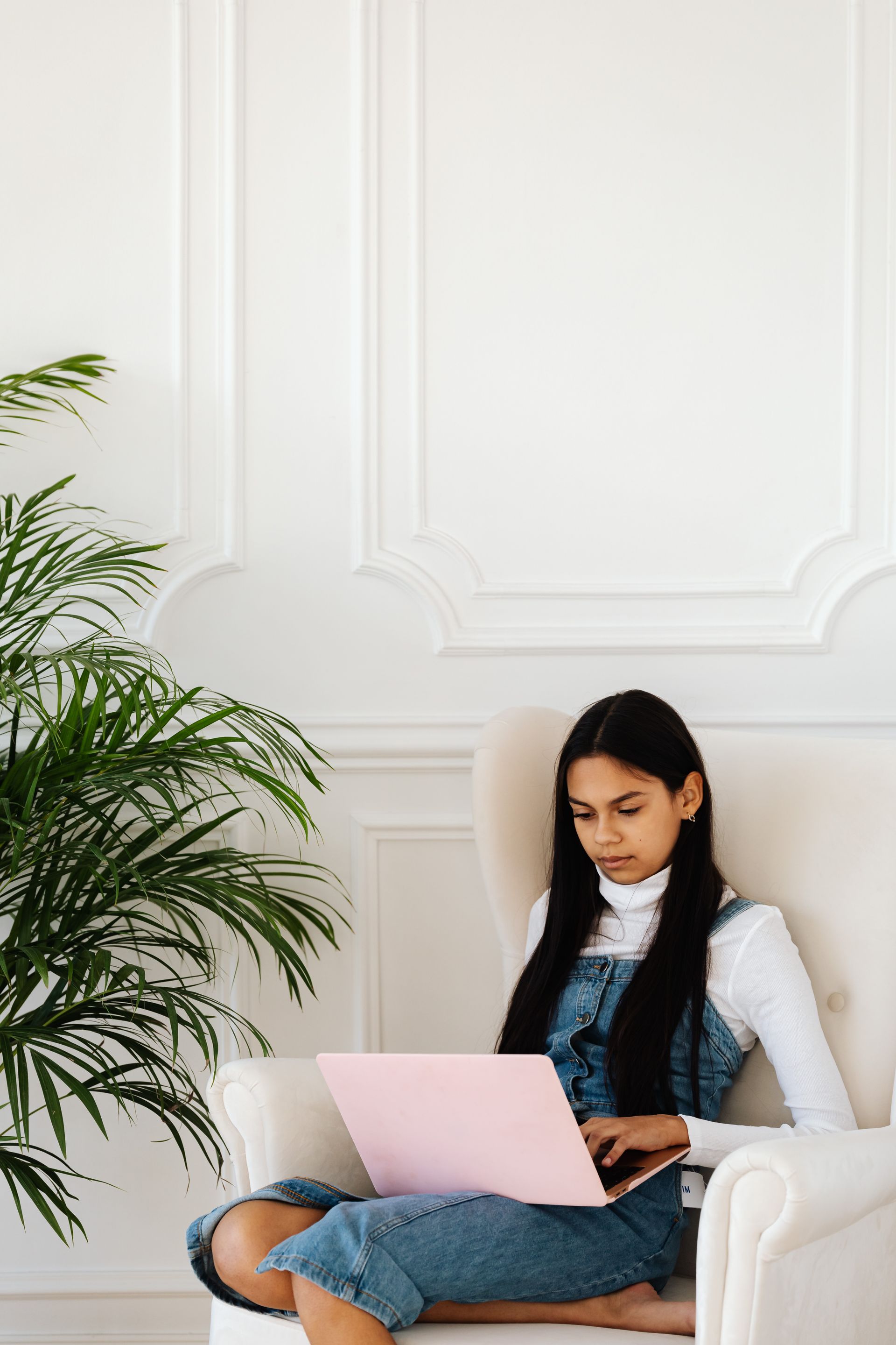 Teen girl sitting down with a notebook computer on her lap