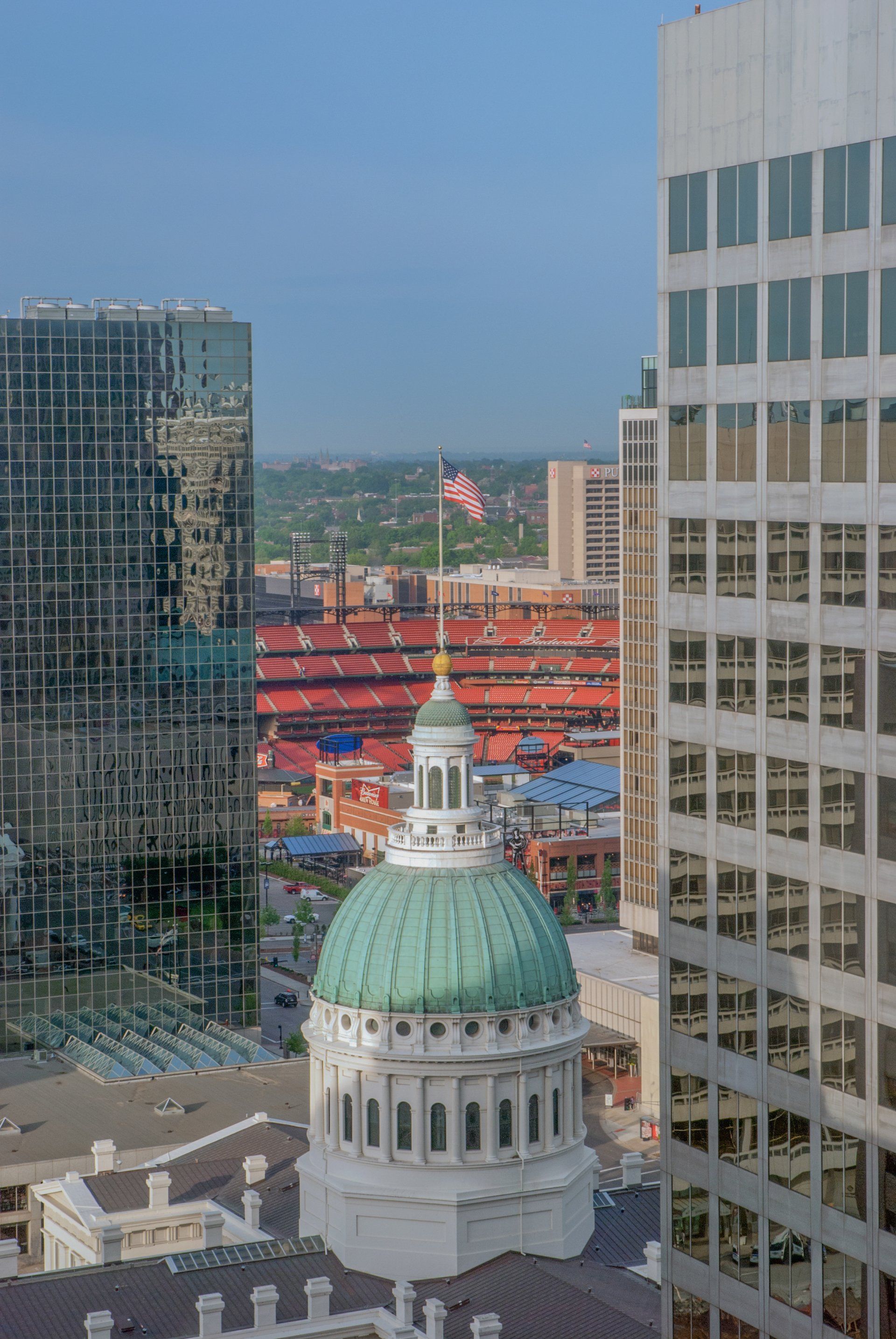 An aerial view of a city with a dome and a flag on top of it.